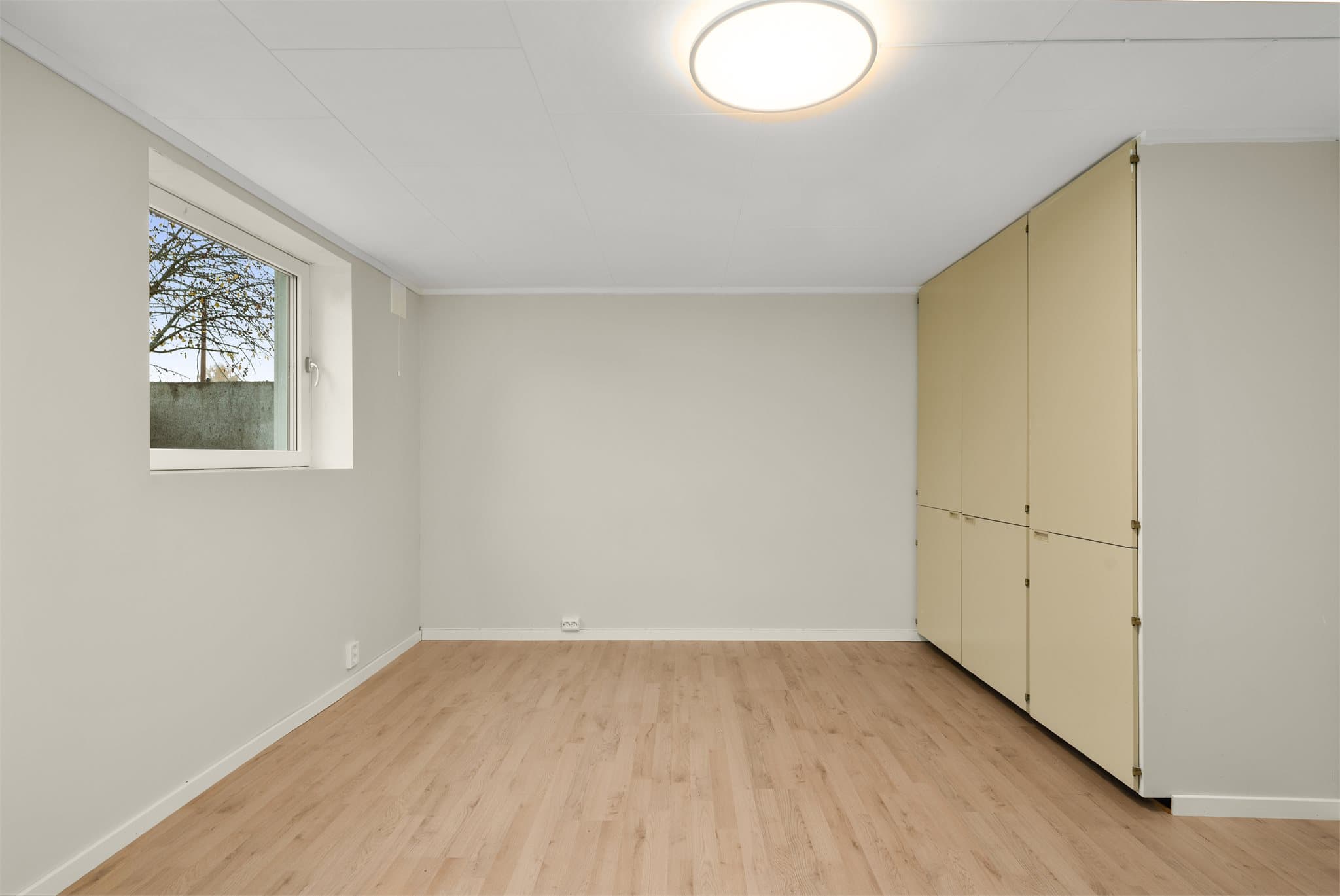 Soverom med innbygget skaprekke og parkett på gulv.