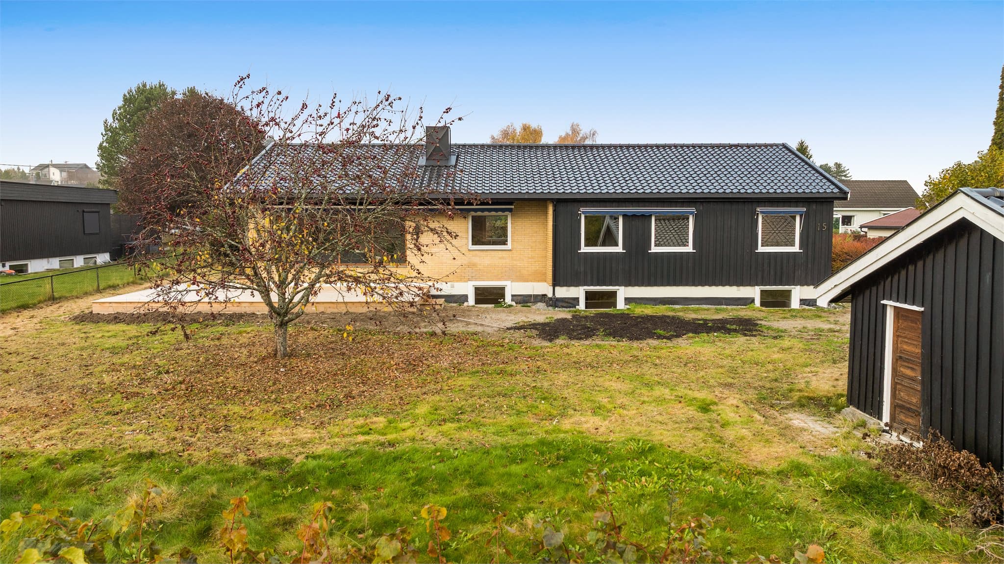 Tomten er relativt flat og pent innrammet av hekk og gjerde. Tomten i forkant hvor garasjen er plassert er skilt ut og hører ikke med