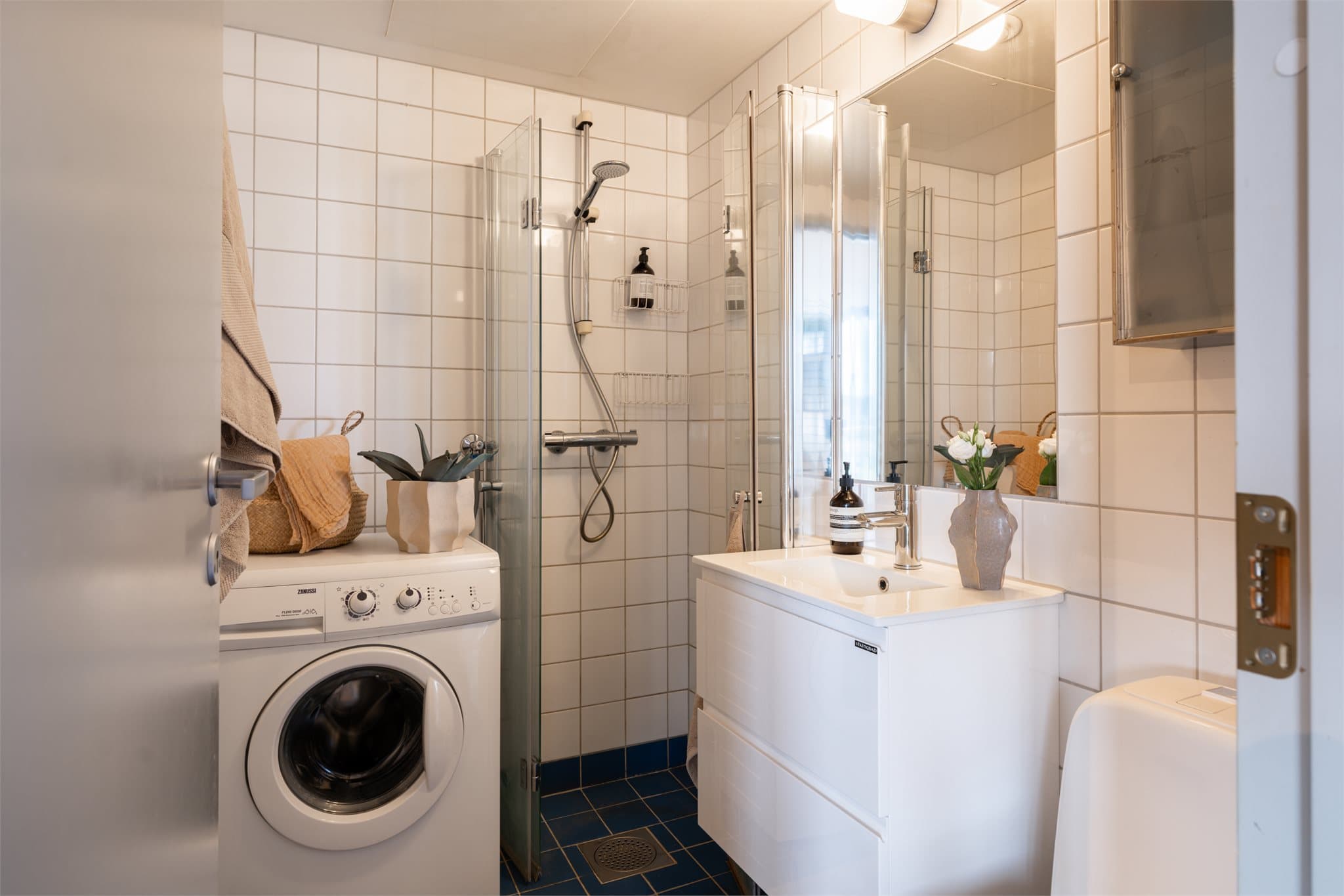 Flislagt bad med gulvvarme, opplegg for vaskemaskin og innfelte dusjdører.