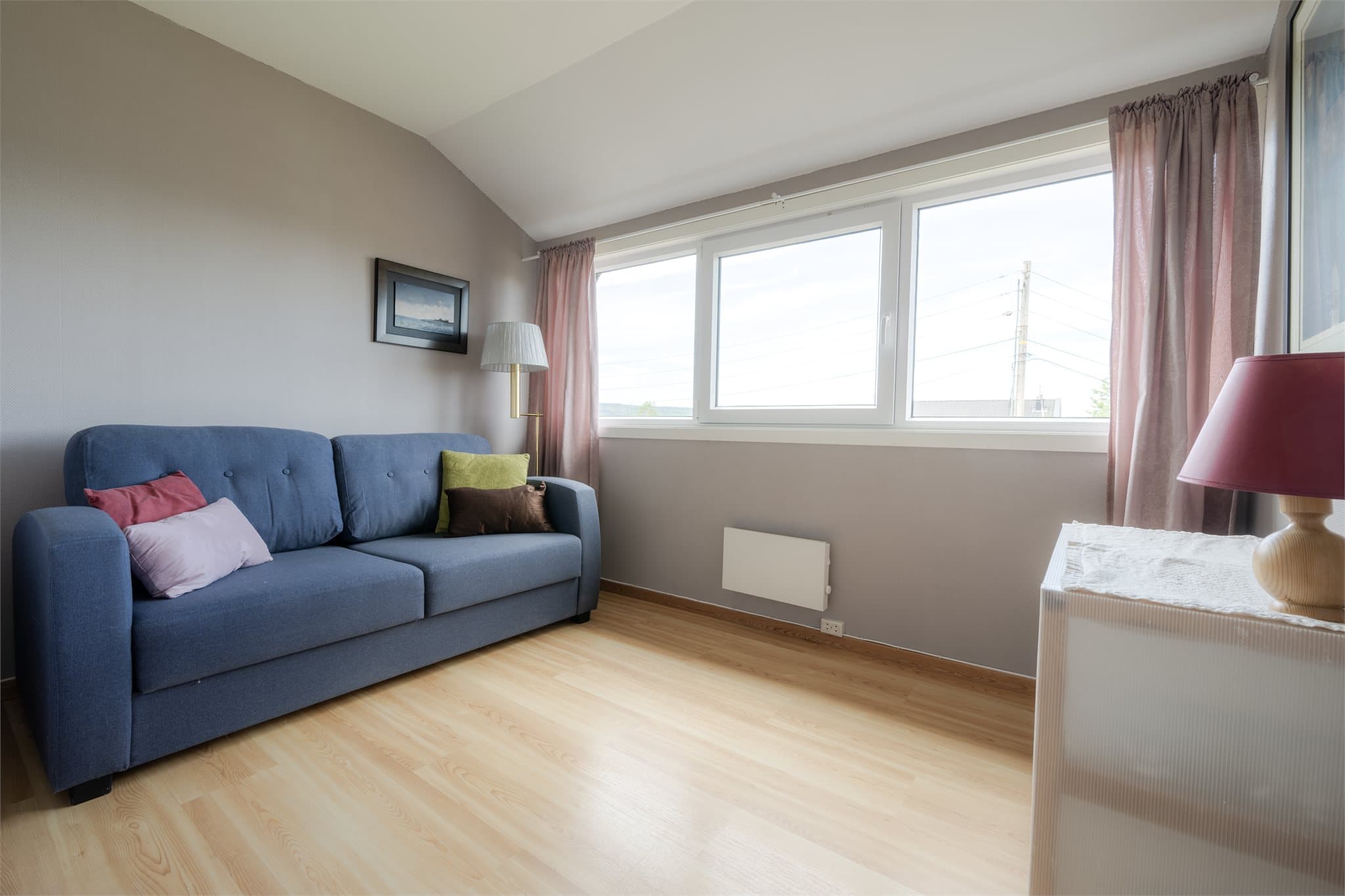 Soverom 4 - Et lyst og romslig soverom med god plass til både seng, sofa eller hjemmekontor. Det store vinduet slipper inn rikelig med dagslys og skaper en rolig atmosfære.