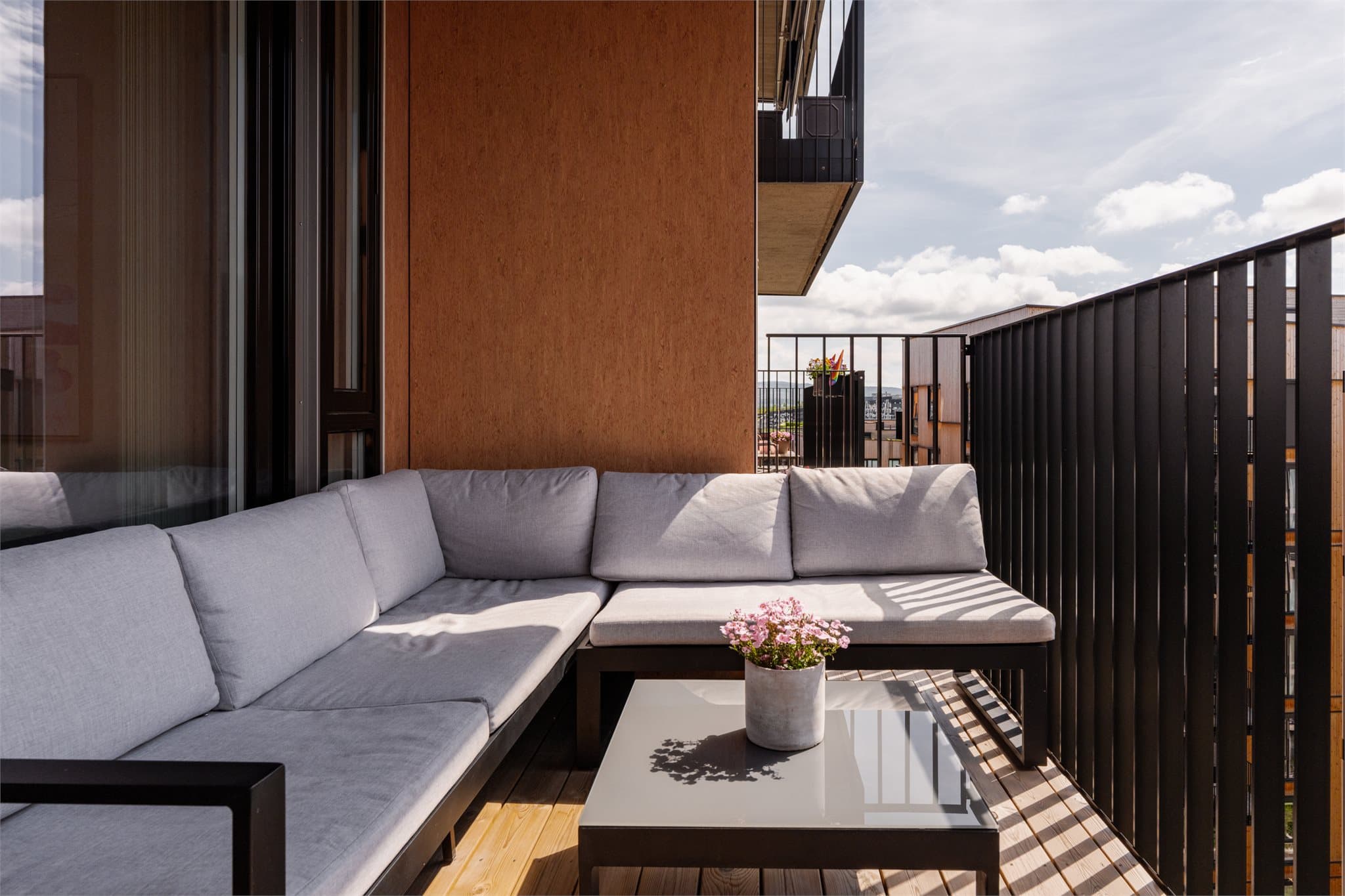 Bygget har stilfull arkitektur med varme trefarger på sideveggene kombinert med lekkert terrassegulv i tre.