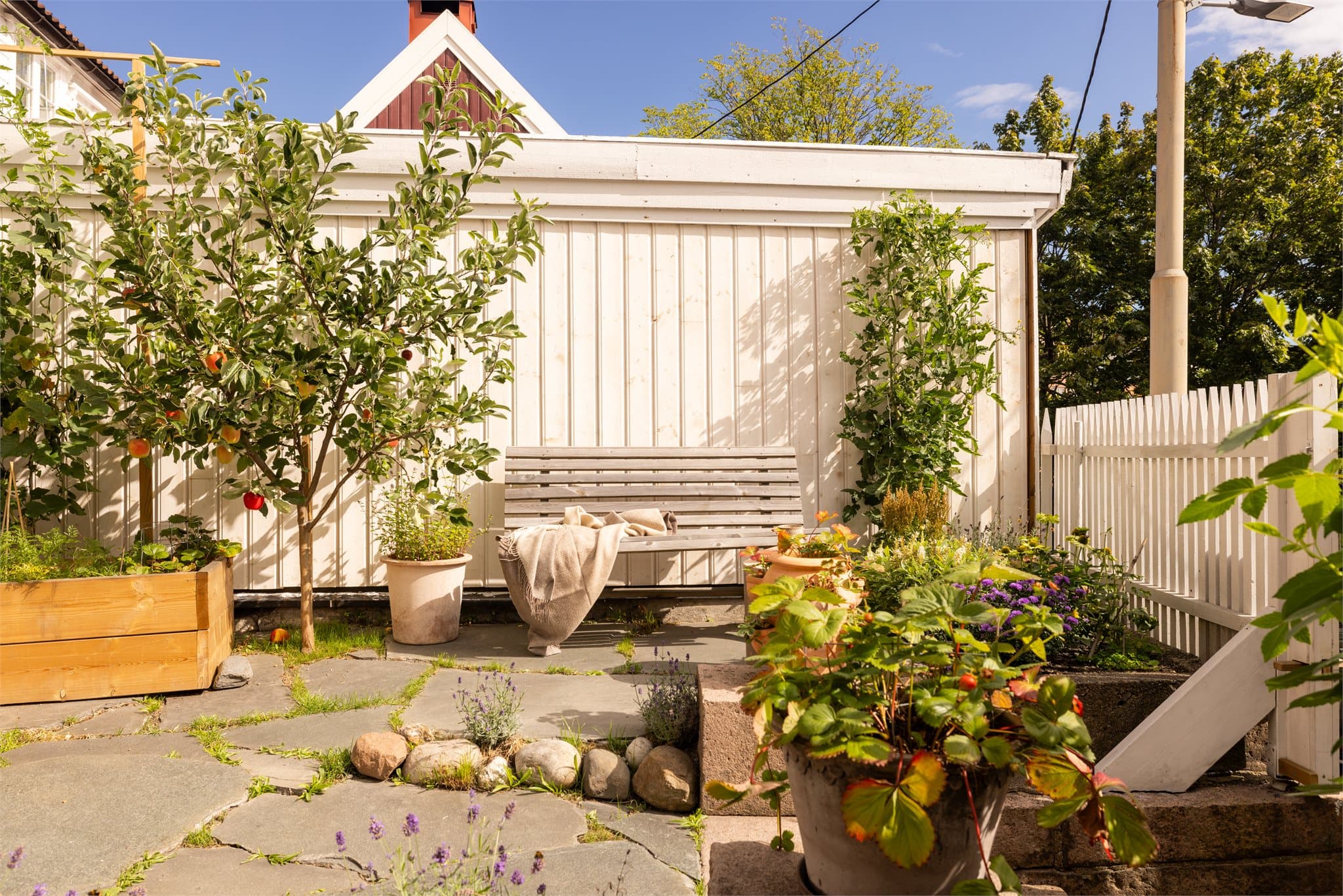 Per i dag har uteplassen frodige blomsterbed, egenproduserte tomater og epletrær.