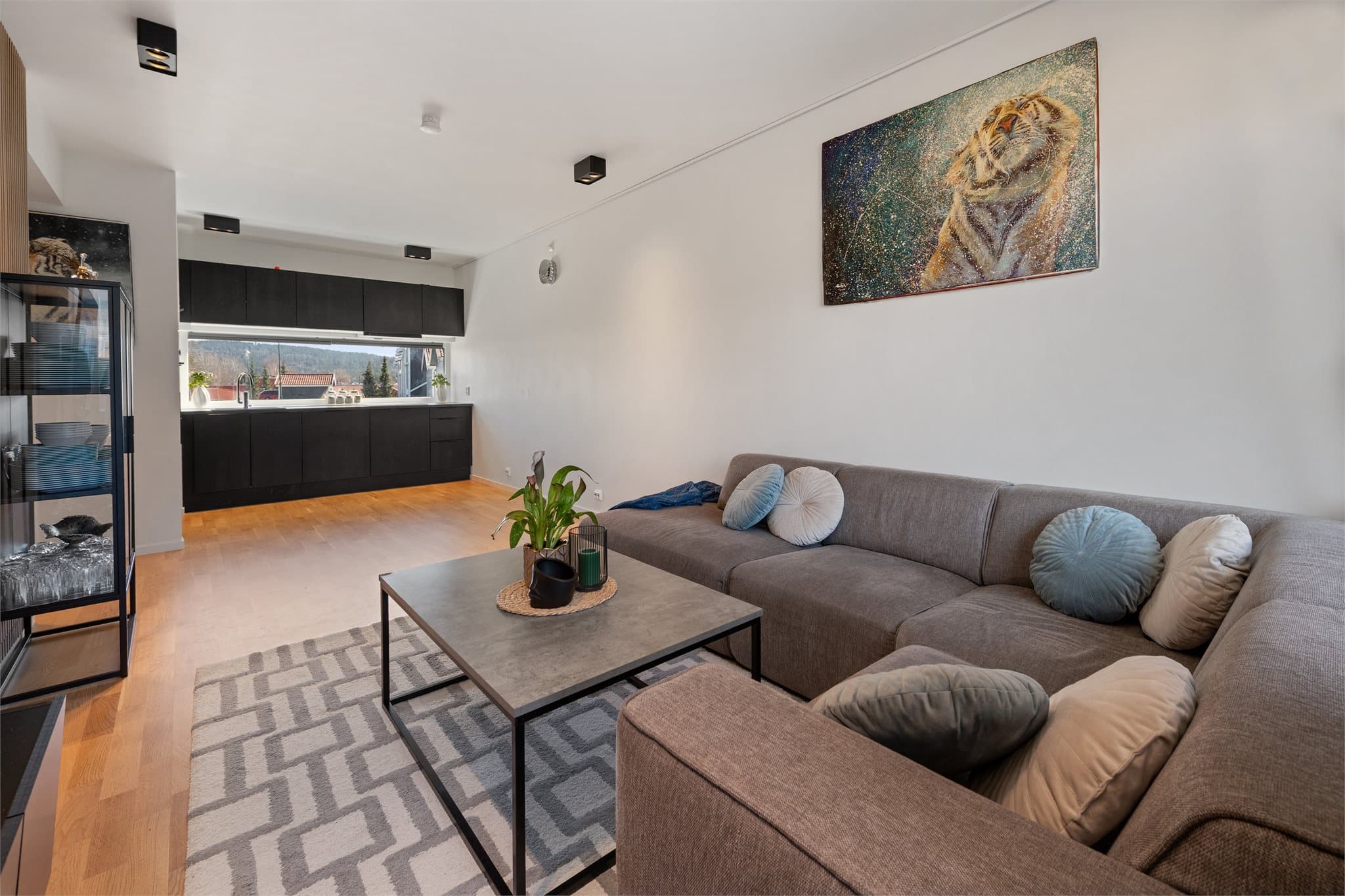 Stor stue som enkelt kan møbleres med spisebord ved kjøkkenet og stor sofa