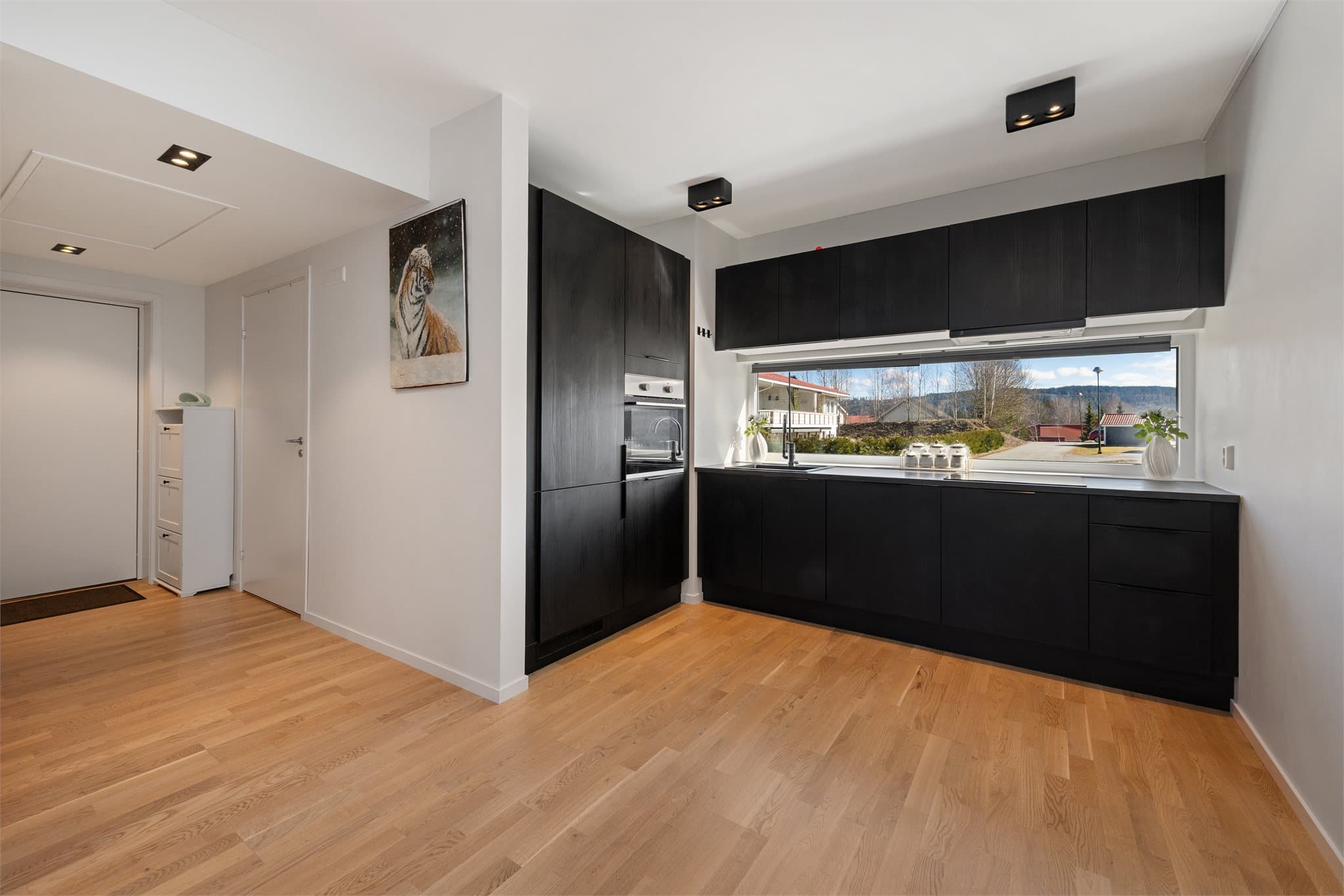 Kjøkken med integrerte hvitevarer. Kjøkken over benk gir gode naturlige lysforhold og fin utsikt