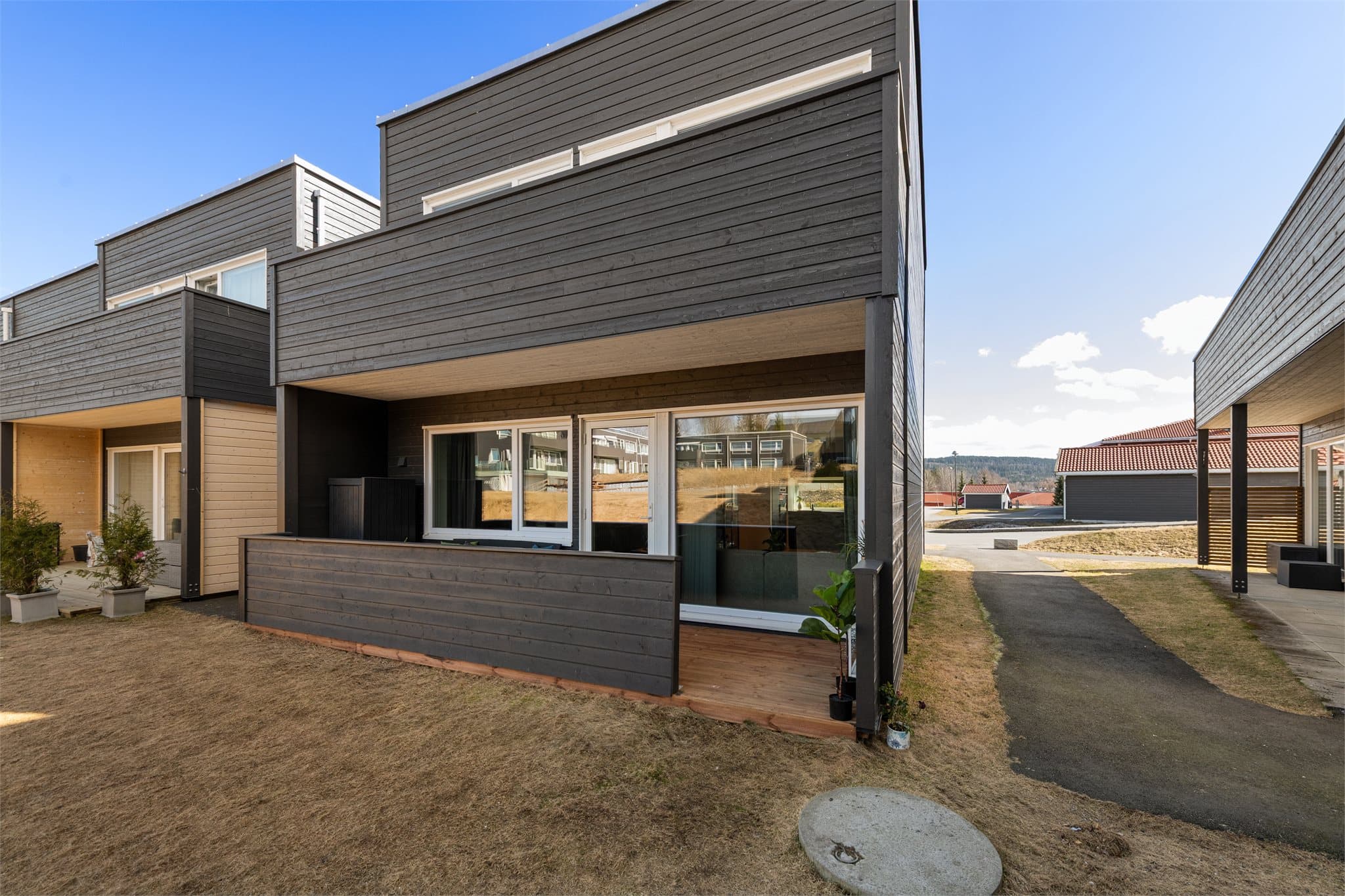 Hyggelig vestvendt og skjermet terrasse vendt mot hyggelige fellesområder. Foto tatt kl. 13 på dagen så solen har ikke rukket å komme rundt enda