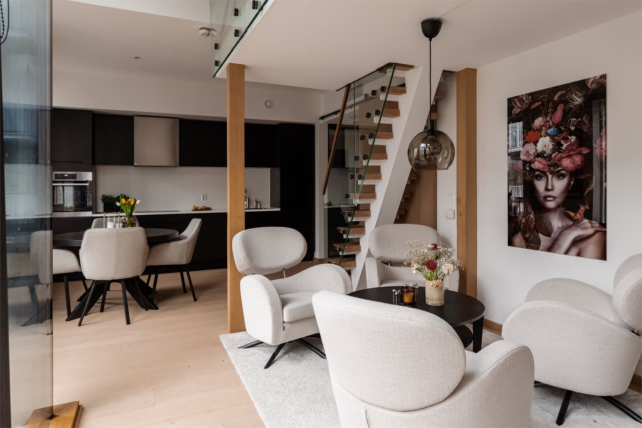 En stilren trapp med detaljer i eik og glass gir rommet et moderne og arkitektonisk uttrykk, samtidig som den bidrar til en luftig romfølelse.