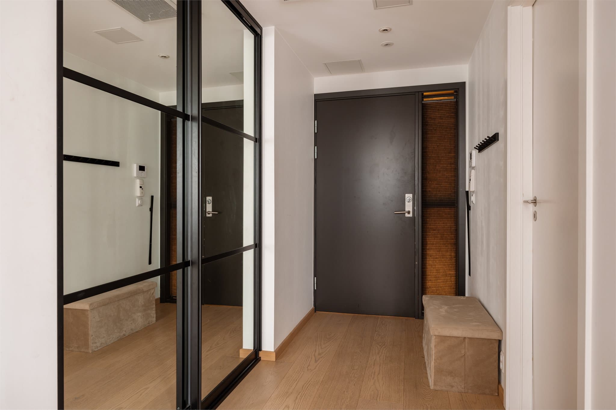 Lys og tiltalende entré med stor skyvedørsgarderobe for oppbevaring av både klær og sko.