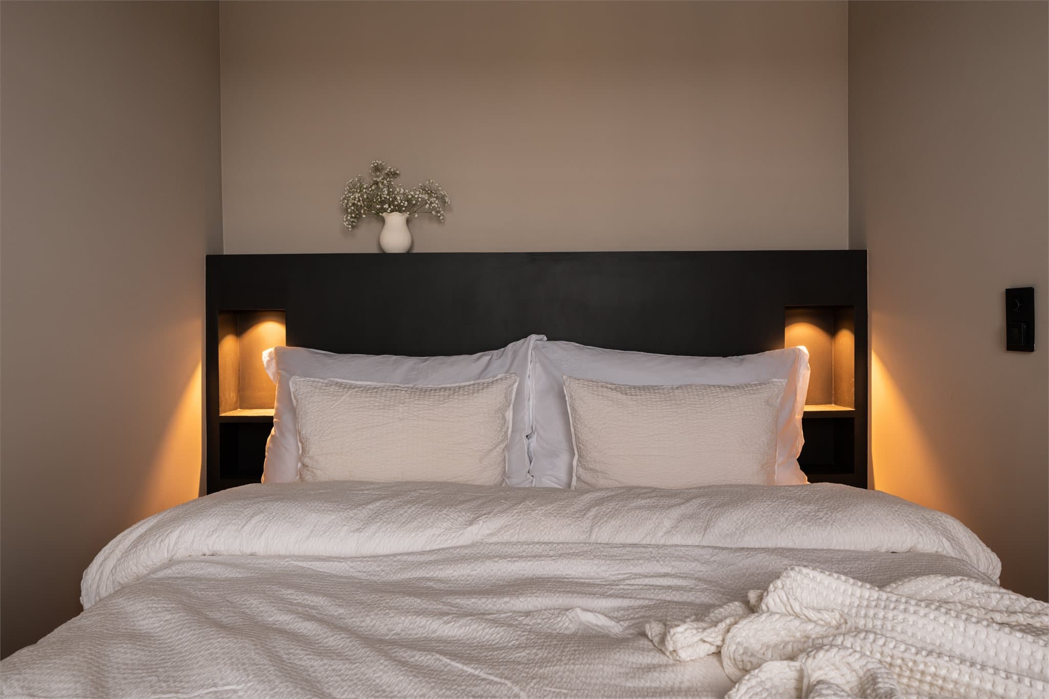 Sengegavlen har integrerte nattbord og praktiske lademuligheter.