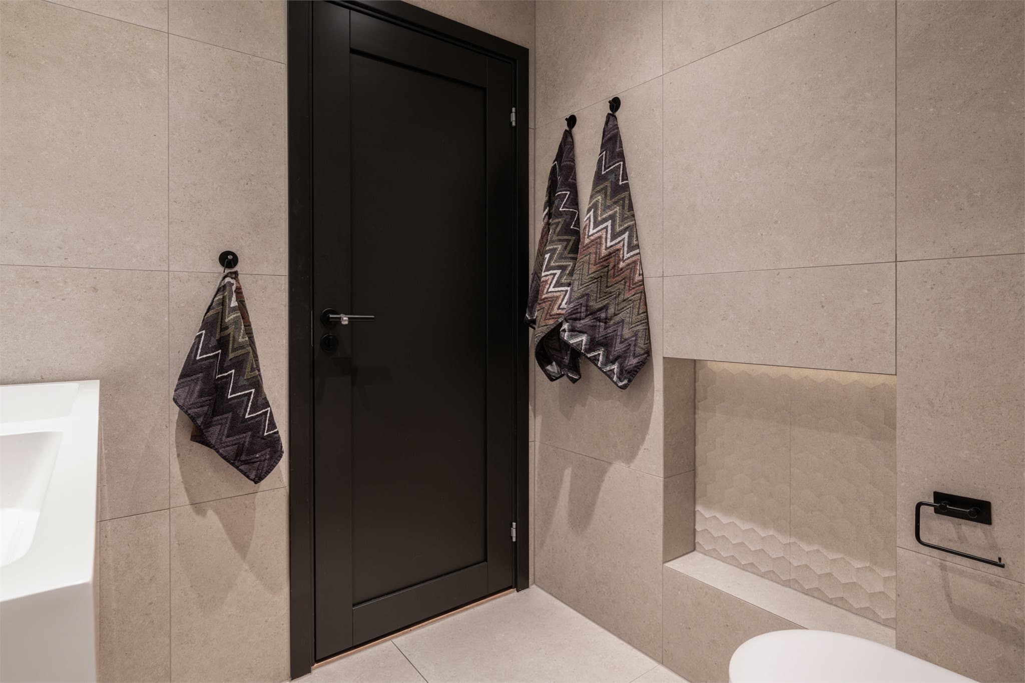 Vegghengt toalett og sorte detaljer gir et ryddig og moderne uttrykk.