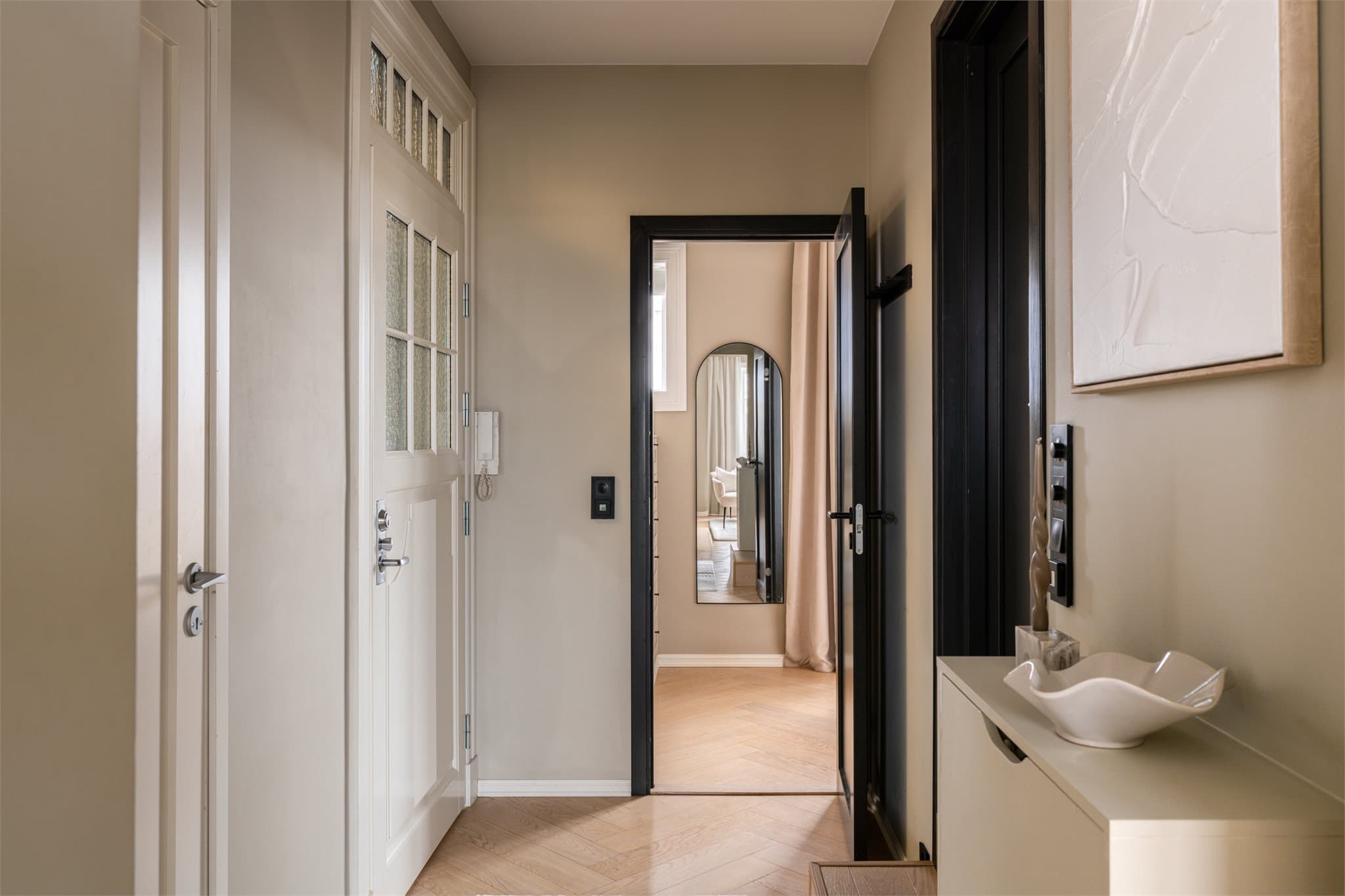 Den innbydende entréen har gjennomgående eikeparkett i fiskebensmønster med varmefolie.