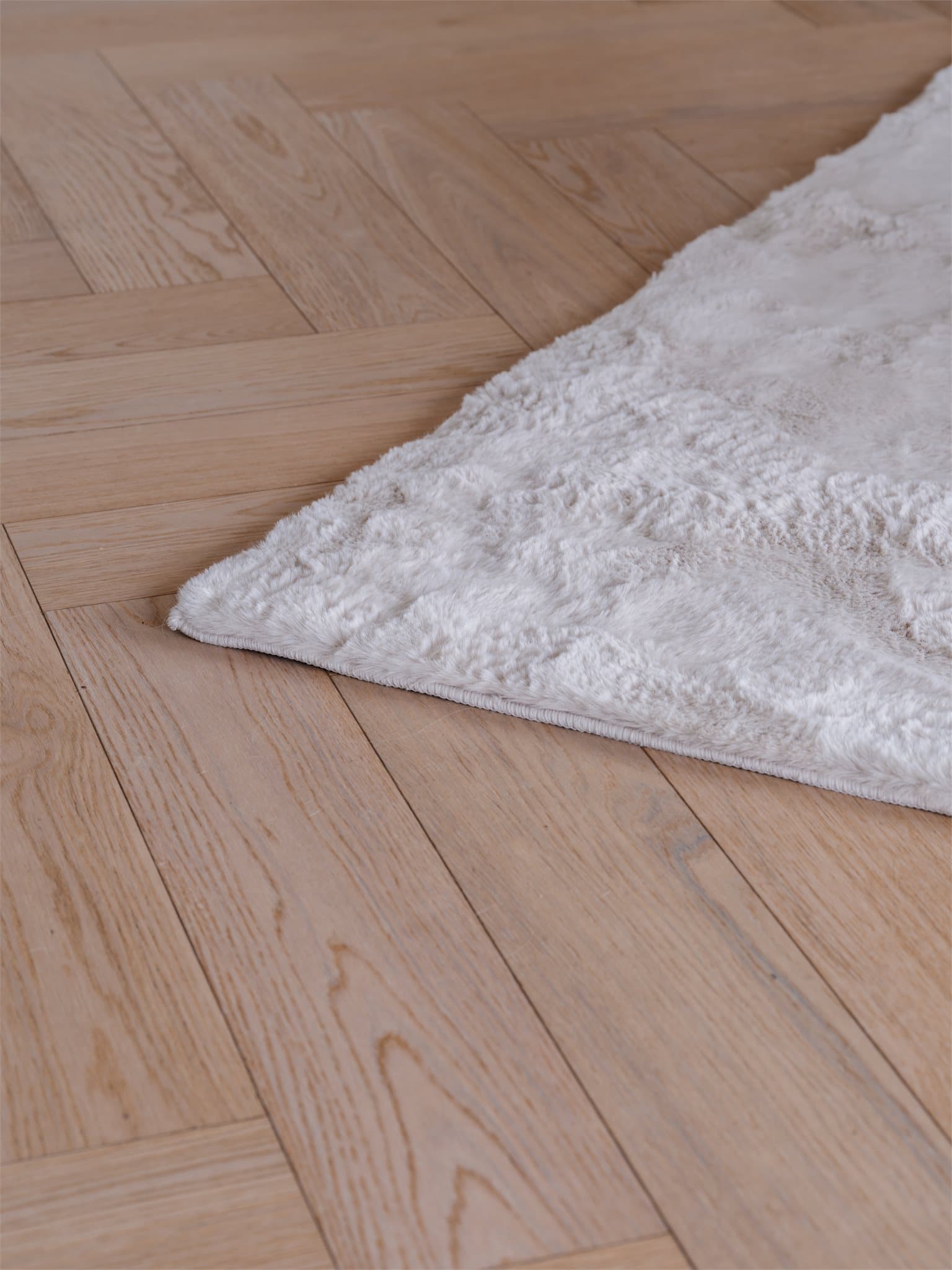 Gjennomgående eikeparkett i fiskebensmønster med varmefolie binder rommene elegant sammen.