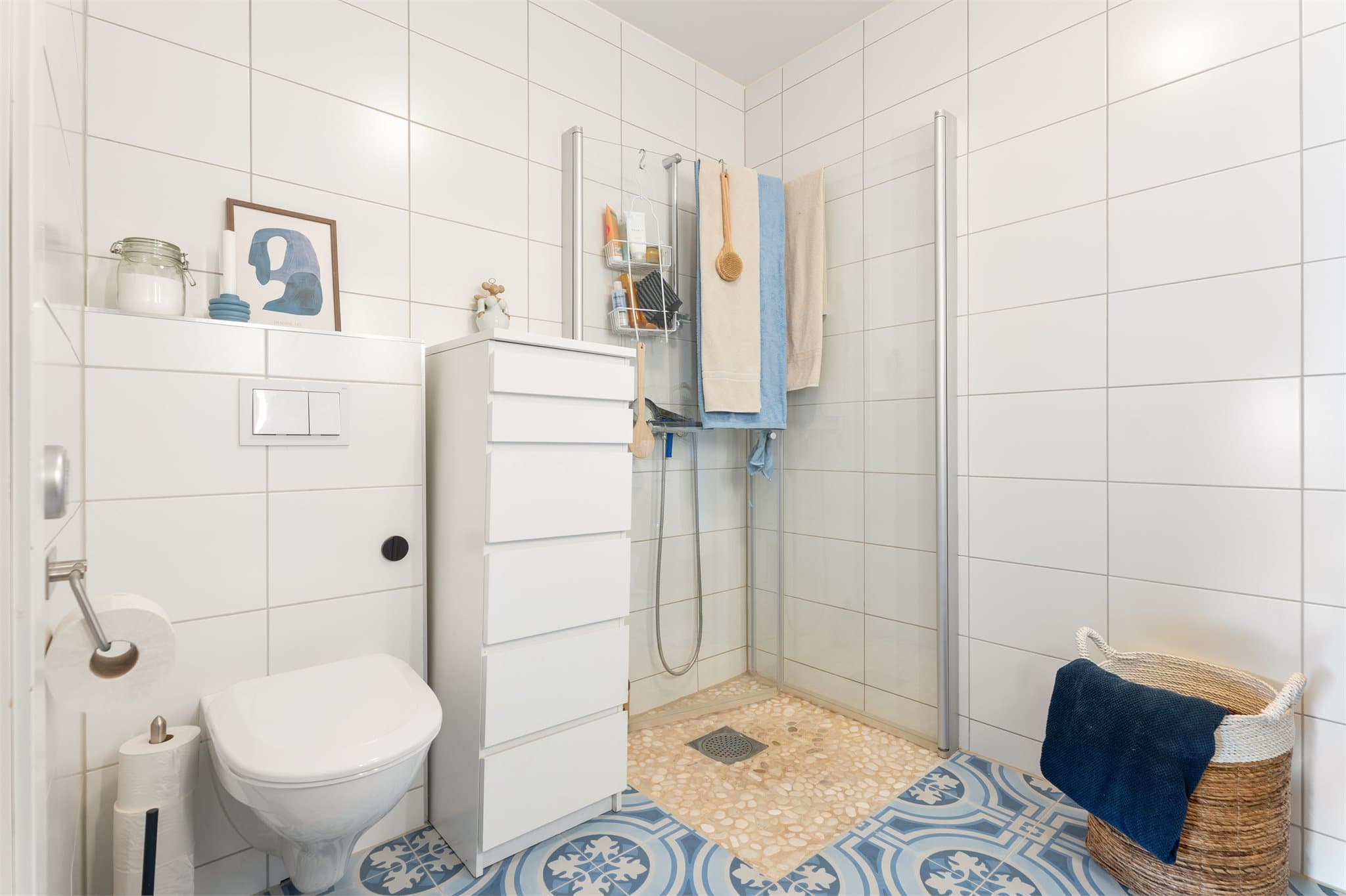 Badet er praktisk innredet med toalett, servant og dusjløsning med innfellbare dusjdører, i tillegg til opplegg for vaskemaskin.