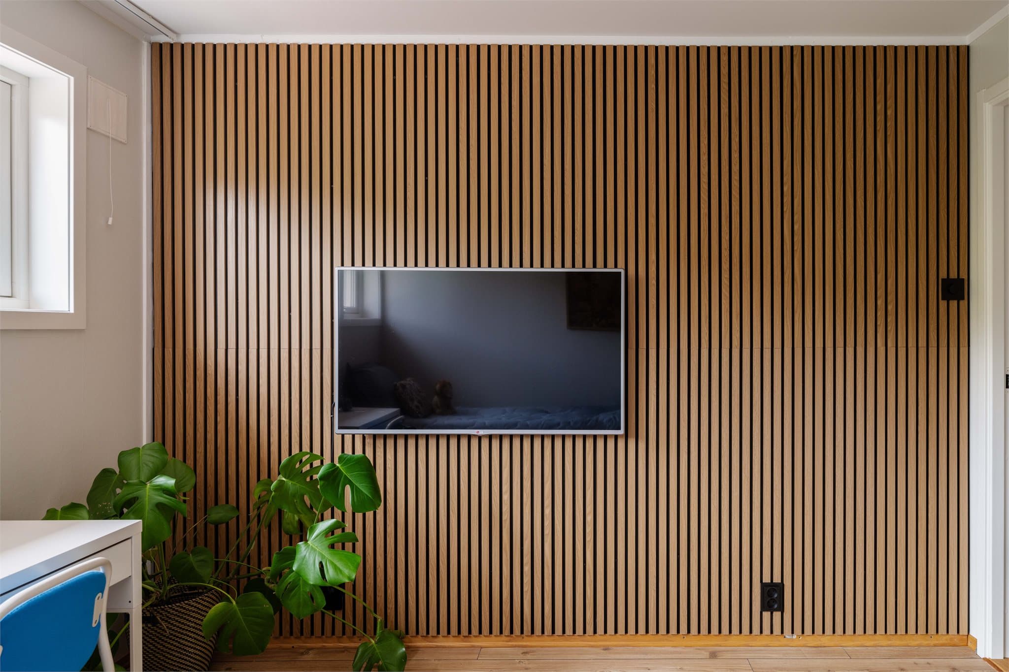 En vegg med spilepanel gir rommet et moderne og lunt preg.