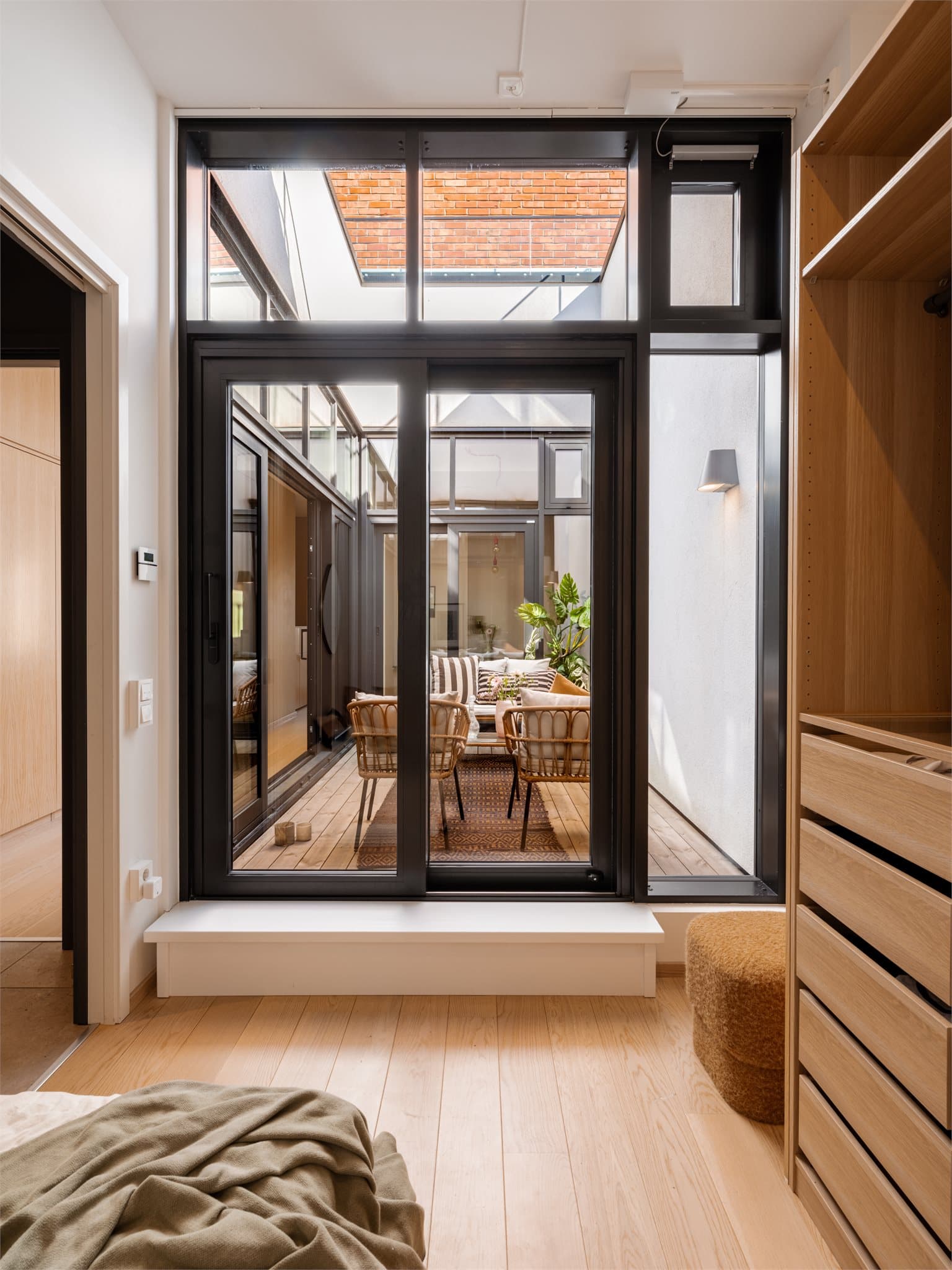 Atriet fungerer som en naturlig forlengelse av rommene og gir en følelse av å være utendørs, samtidig som det skjermer for innsyn.