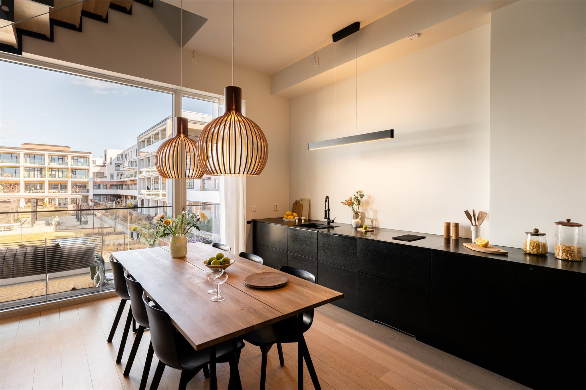 Kjøkkenet er utstyrt med stilrene, glatte skapfronter og en slitesterk benkeplate i kompakt-laminat som gir et moderne og minimalistisk uttrykk.