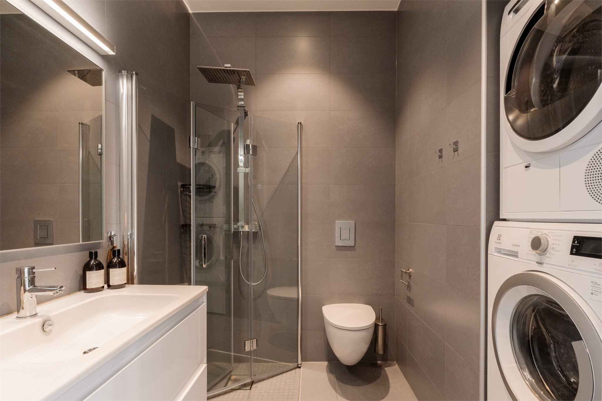 I leilighetens første etasje finner du et moderne og pent baderom som kombinerer funksjonalitet med stilrene detaljer.