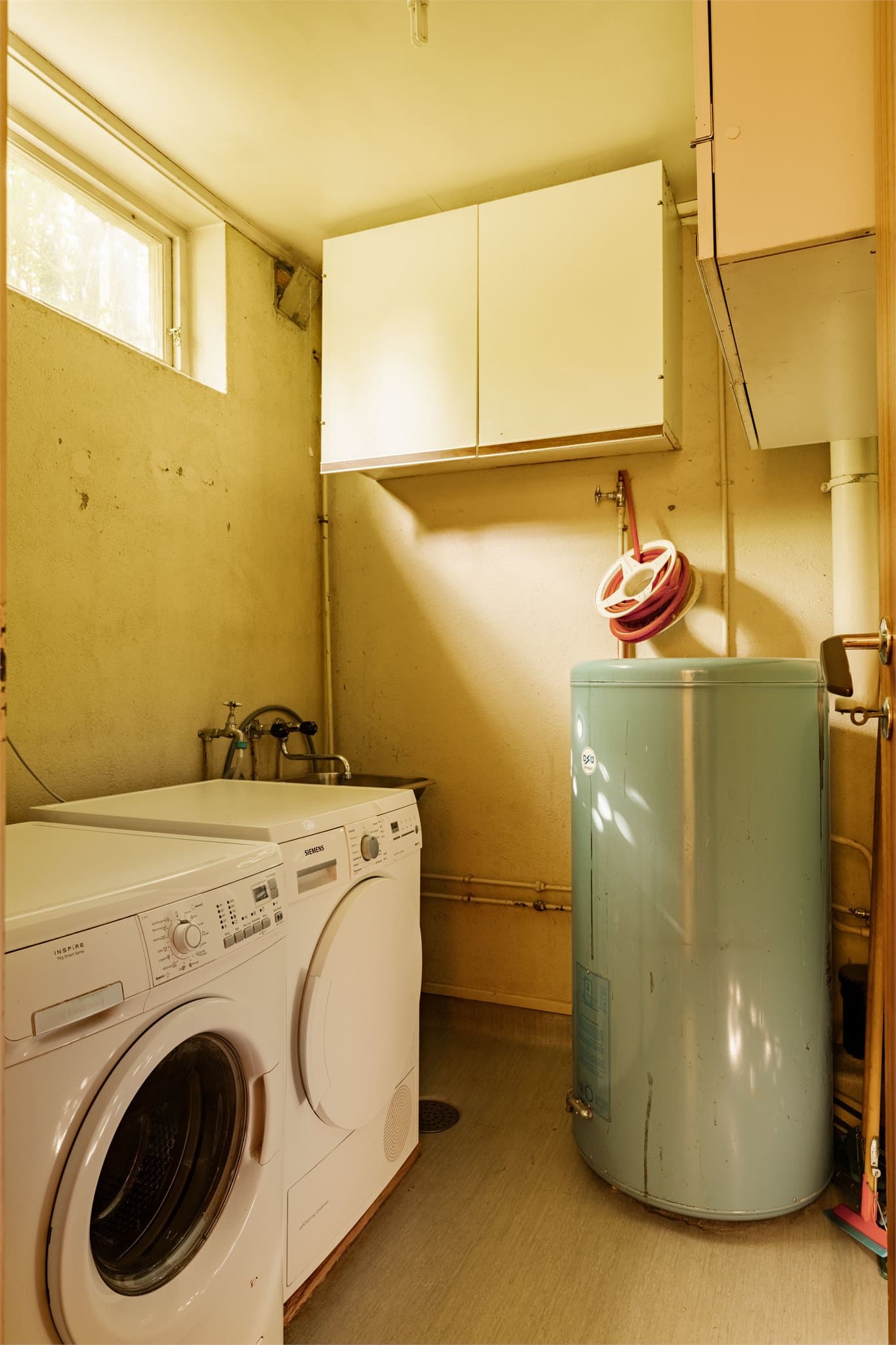 Ved siden av badet ligger et vaskerom med opplegg for vaskemaskin og tørketrommel samt utslagsvask. Varmtvannsberederen er plassert i dette rommet, et rom de fleste familier drømmer om, men som ofte er glemt i nyere boliger.