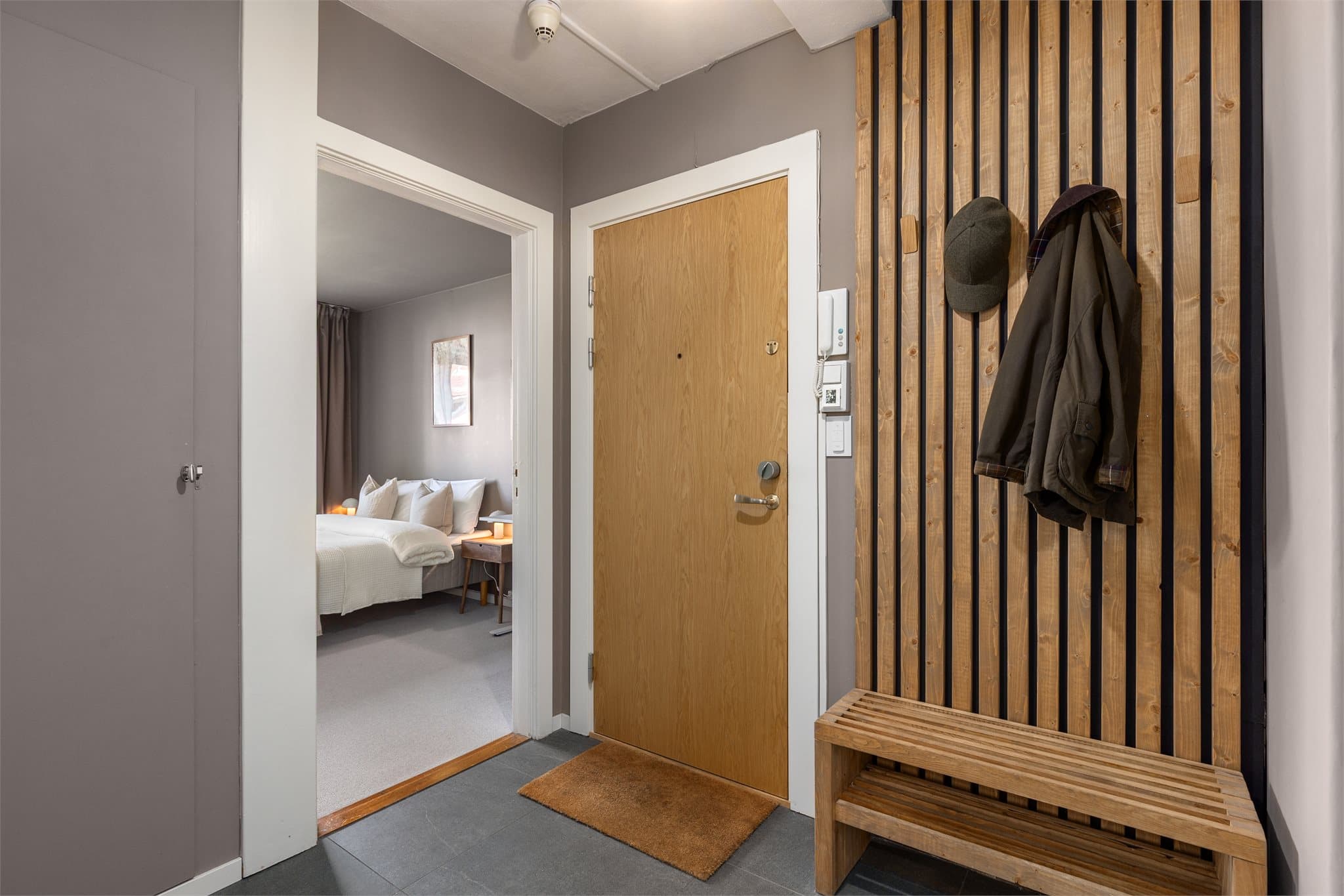 Romslig entré som ble pusset opp i 2023 med gulvvarme i fliser og praktisk spilevegg med plass til å henge fra seg yttertøy og sette fra seg sko