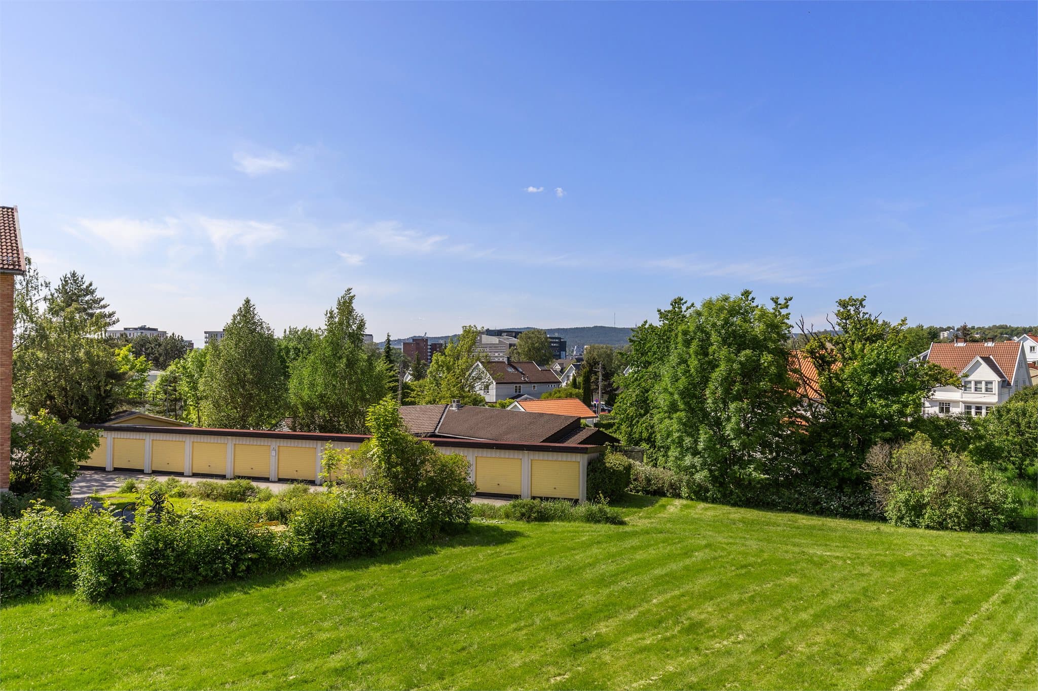 Pent utsyn over borettslagets skjermede og velholdte grøntarealer og helt opp mot Holmenkollen i vest