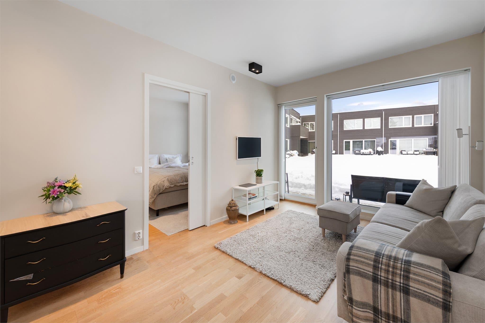 Stue med utgang til terrasse vendt mot hyggelig fellesområde