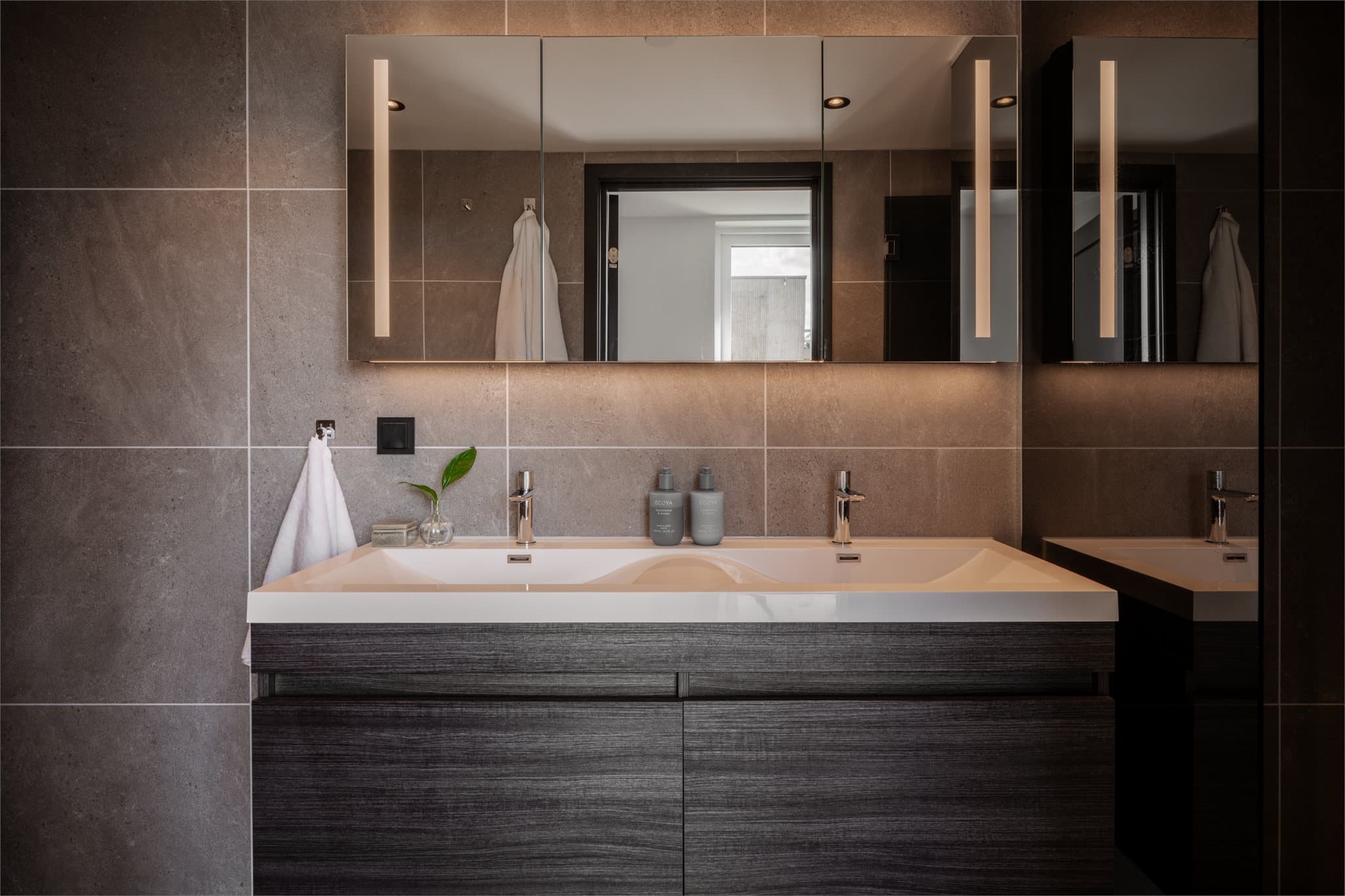Badet har god plass til at flere benytter det samtidig, også med dobbel servant og god skap- og benkeplass.