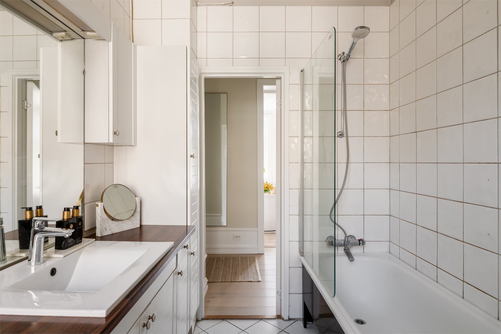 Badekar med glassvegg og heldekkende servant med underskap.