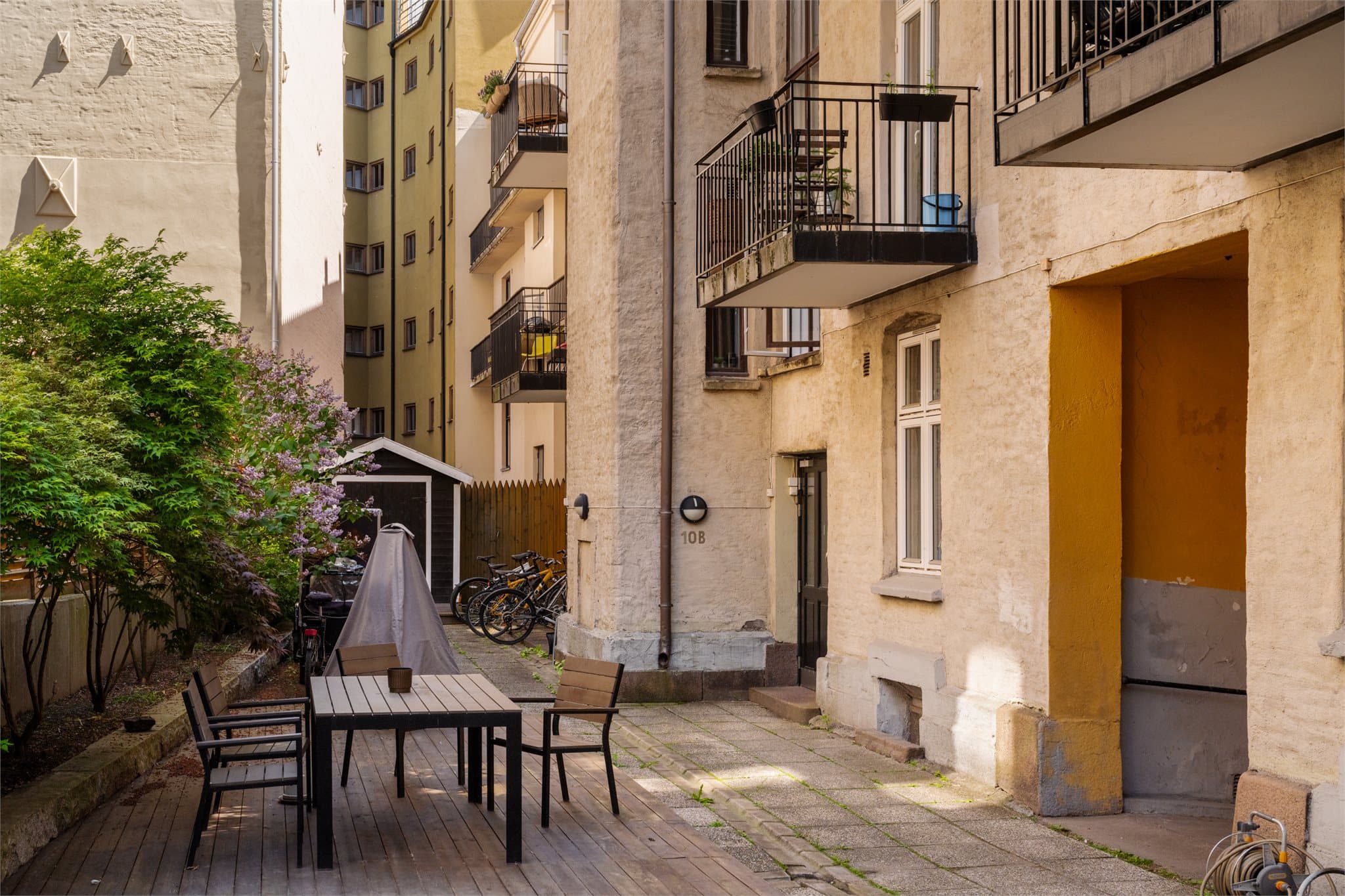 Skjermet bakgård med sykkelparkering og adkomst til oppgang 10B.