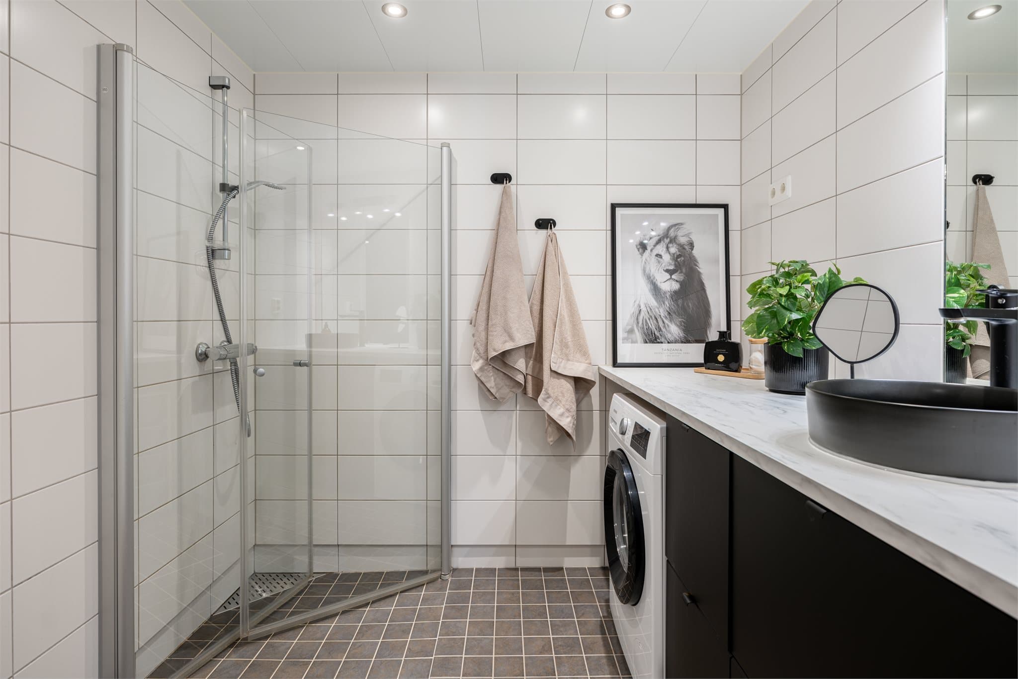 Boligens bad er moderne flislagt, med integrerte downlights i himlingen og varmekabler i gulv.