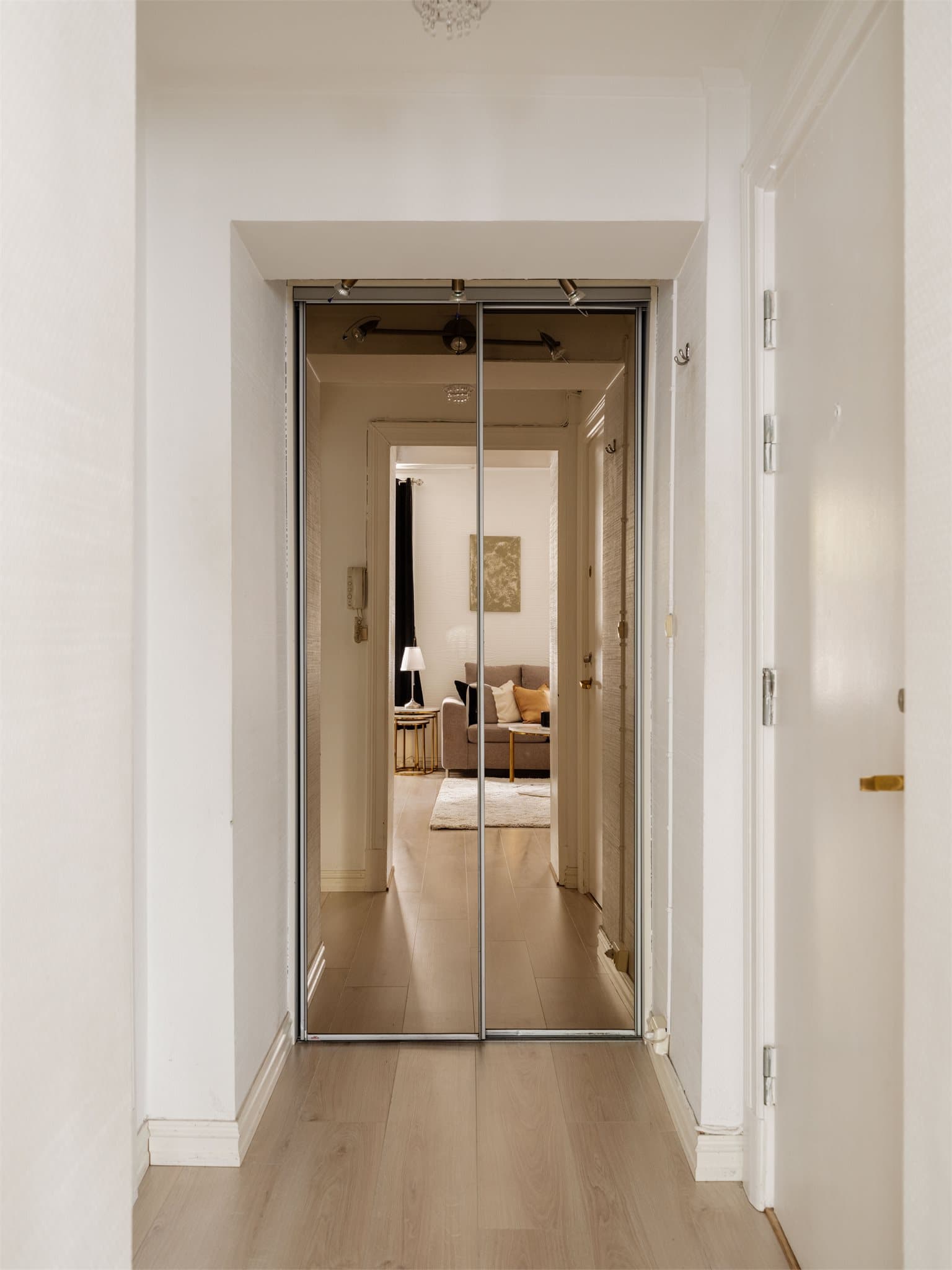 Lys og innbydende entré med praktisk skyvedørsgarderobe med speilfronter som gir en god romfølelse.