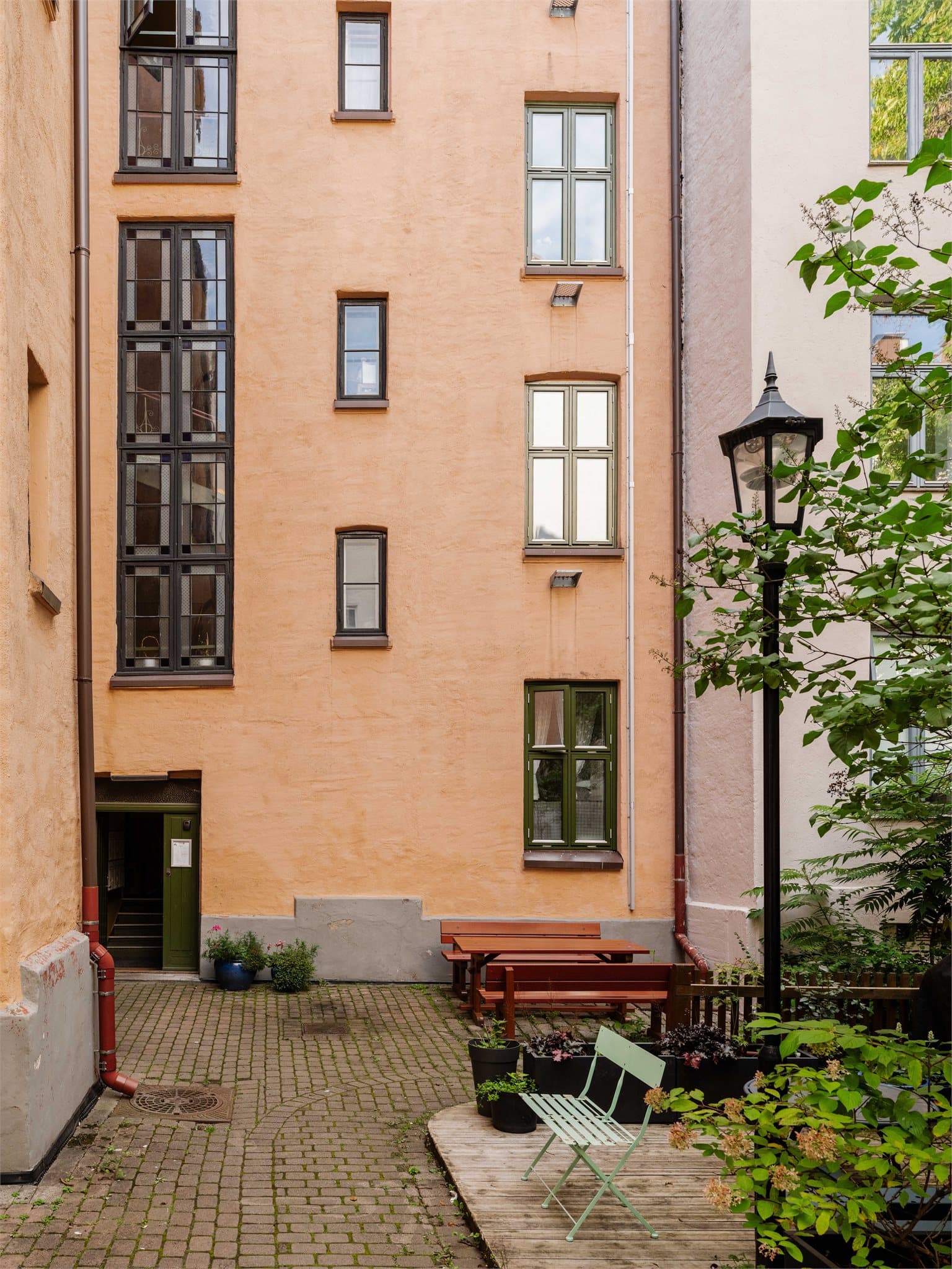 Fleksible og koselige sitteplasser spredt i bakgården som gjør det enkelt å finne både sol og skygge gjennom dagen.