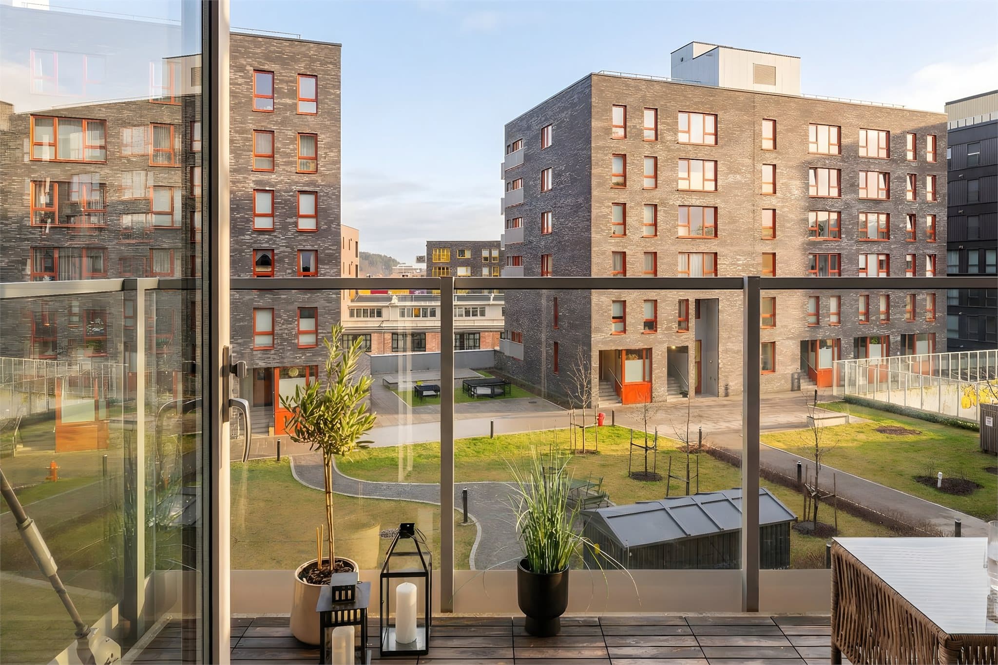 En solrik og romslig balkong vendt mot et rolig gårdsrom.