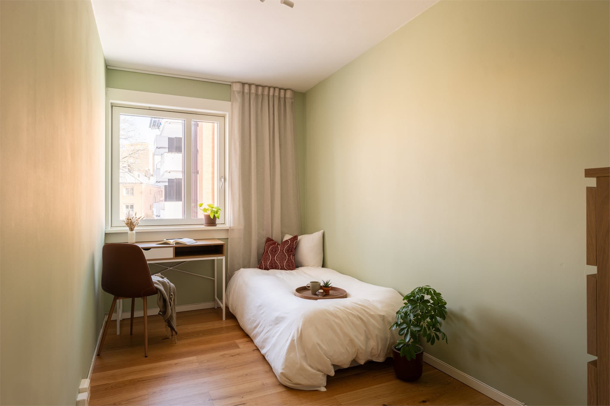 Soverom to er lyst og hyggelig, med duse fargetoner og fint dagslys fra vinduet.