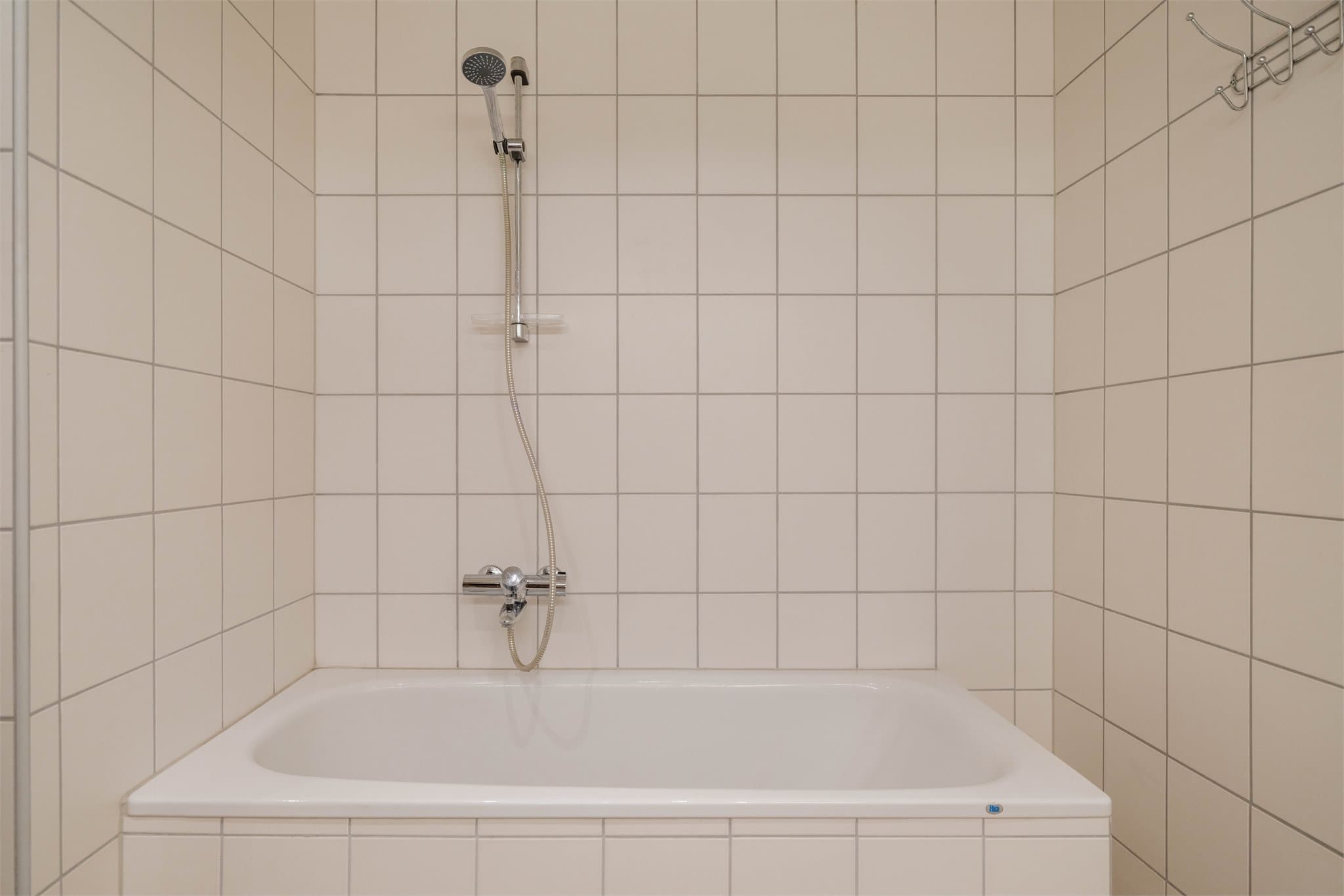Innebygd badekar og flislagte vegger på hovedbadet.