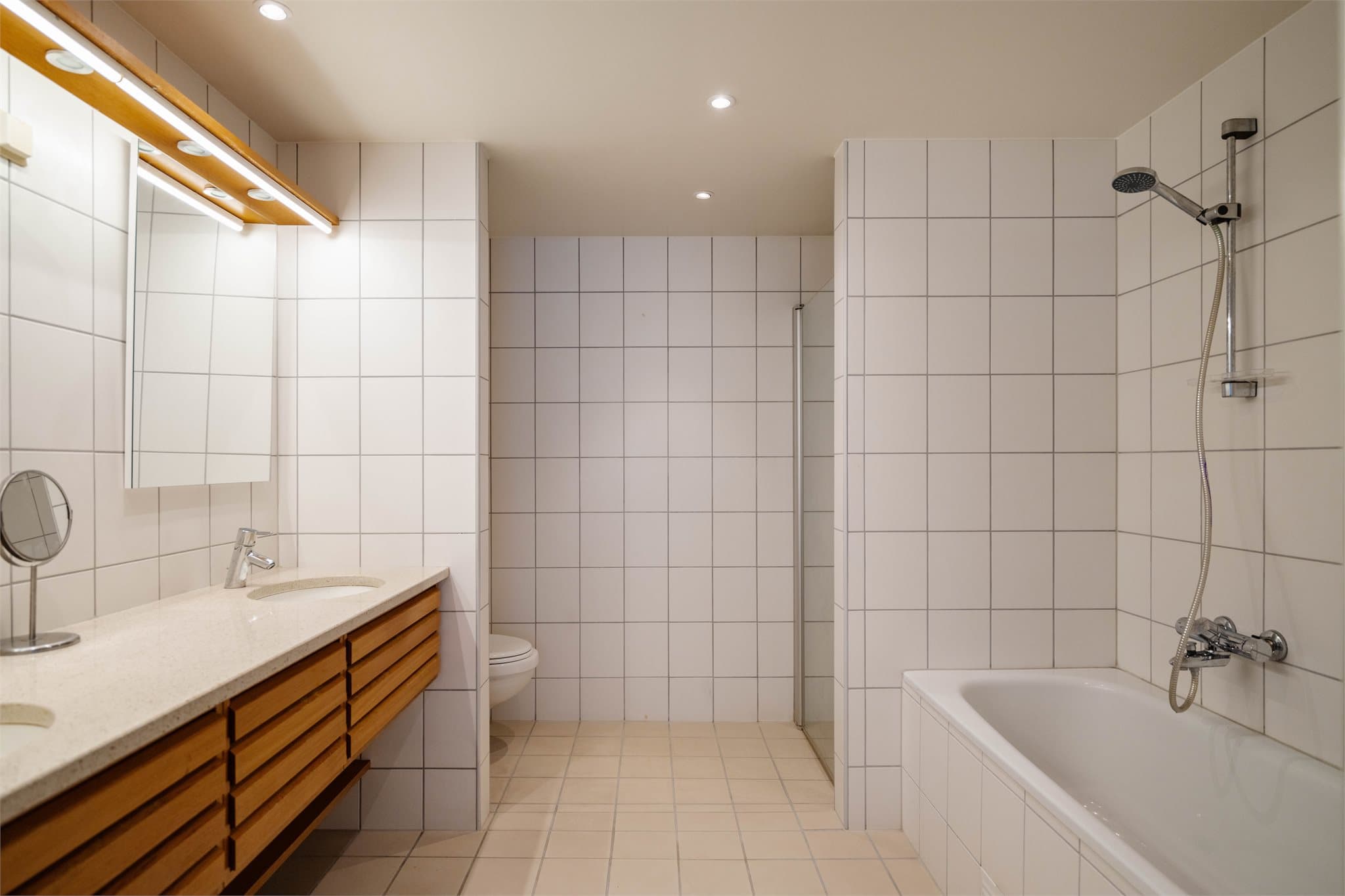 Hovedbadet (tilknyttet soverommet) har flislagte overflater, varmekabler i gulvet, innredning med to servanter, dusjhjørne og badekar.