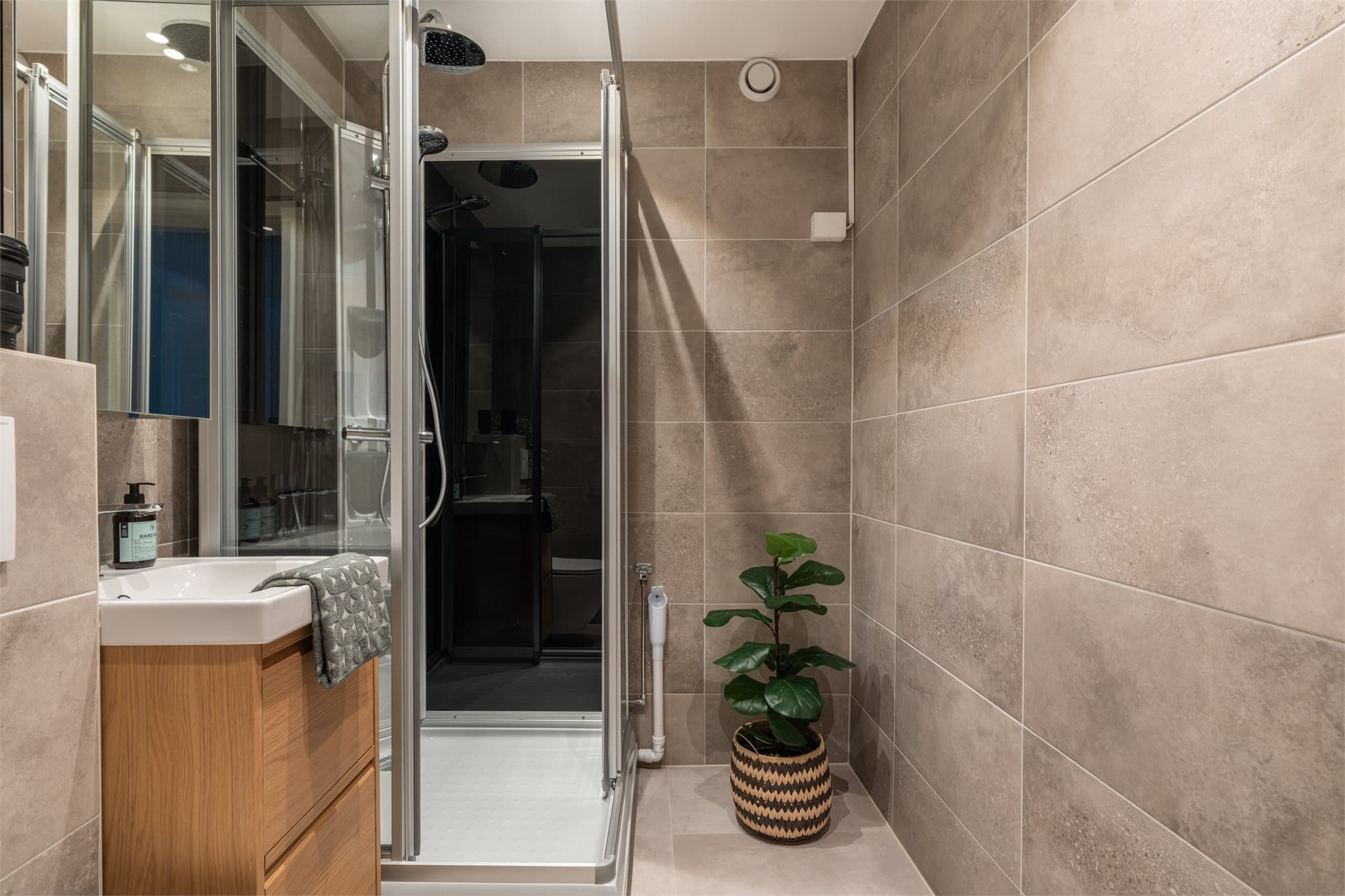 Badet fremstår som moderne med store delikate fliser og er overflate oppusset med flis på flis, ny innredning og 80x90 dusjkabinett med nisjer.