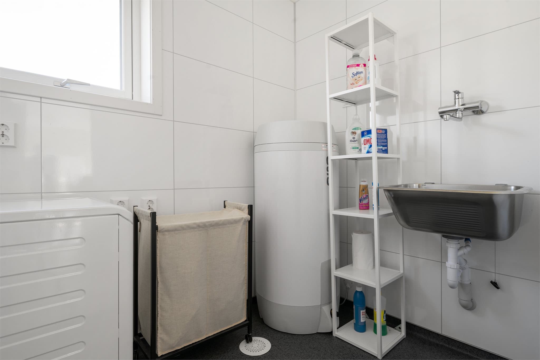 Praktisk vaskerom med utslagsvask og opplegg for vaskemaskin.