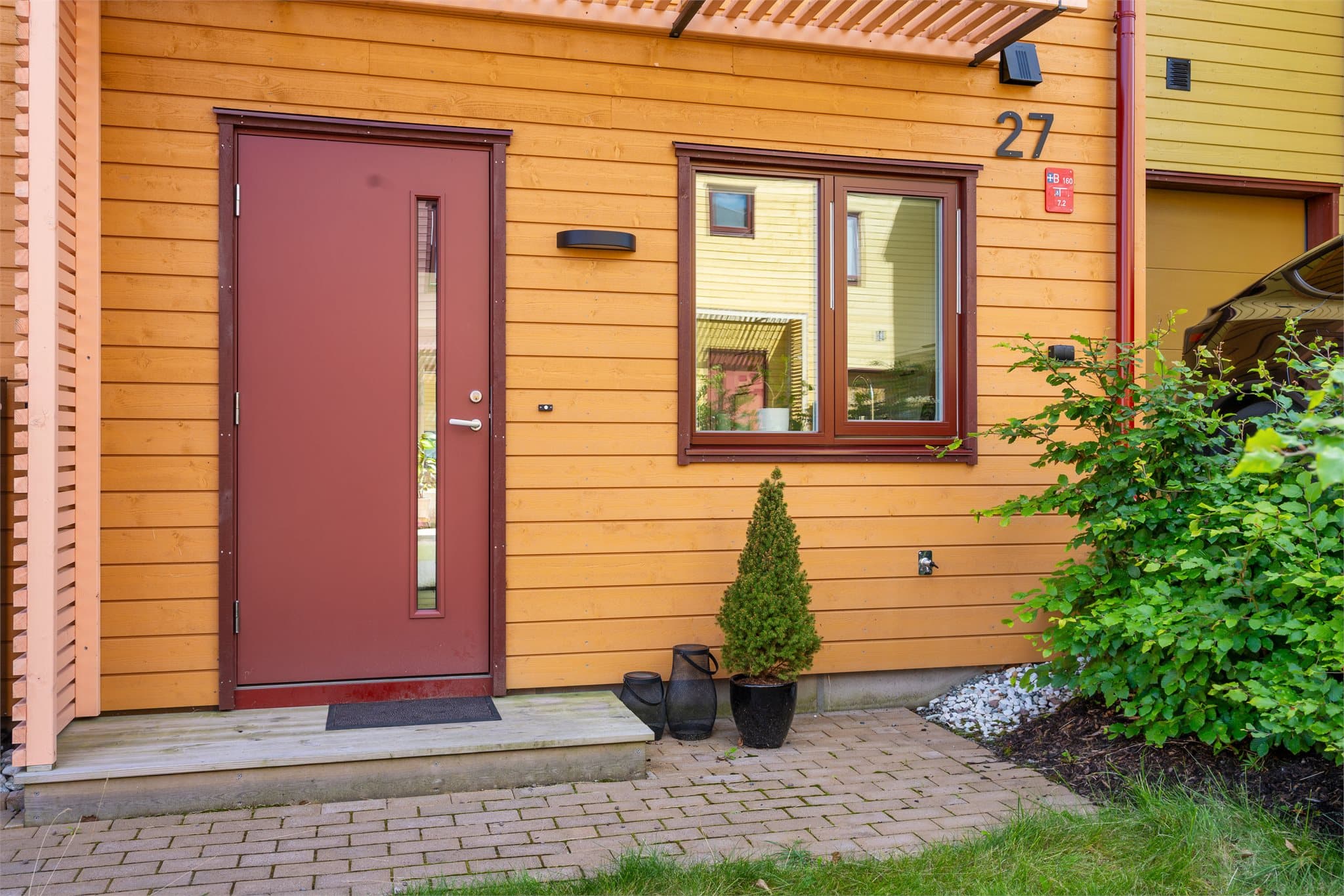 Inngangspartiet har belegningsstein og det er laget et overbygg i spiler.