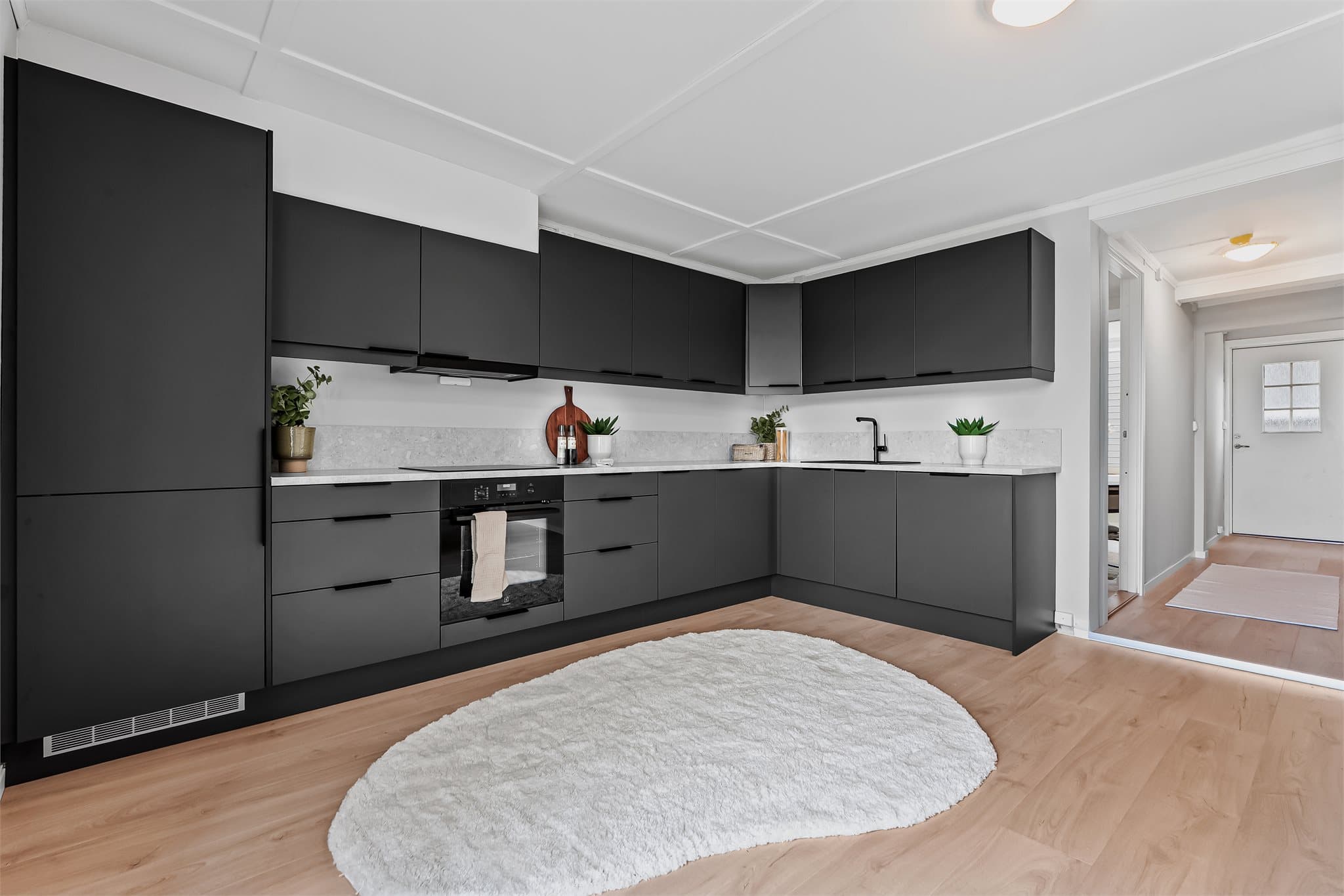 Praktisk og elegant kjøkkeninnredning fra Sigdal med integrerte hvitevarer fra Electrolux, inkludert oppvaskmaskin, kjøl/frys, stekeovn og platetopp. Avtrekksvifte fra Ecotronic.