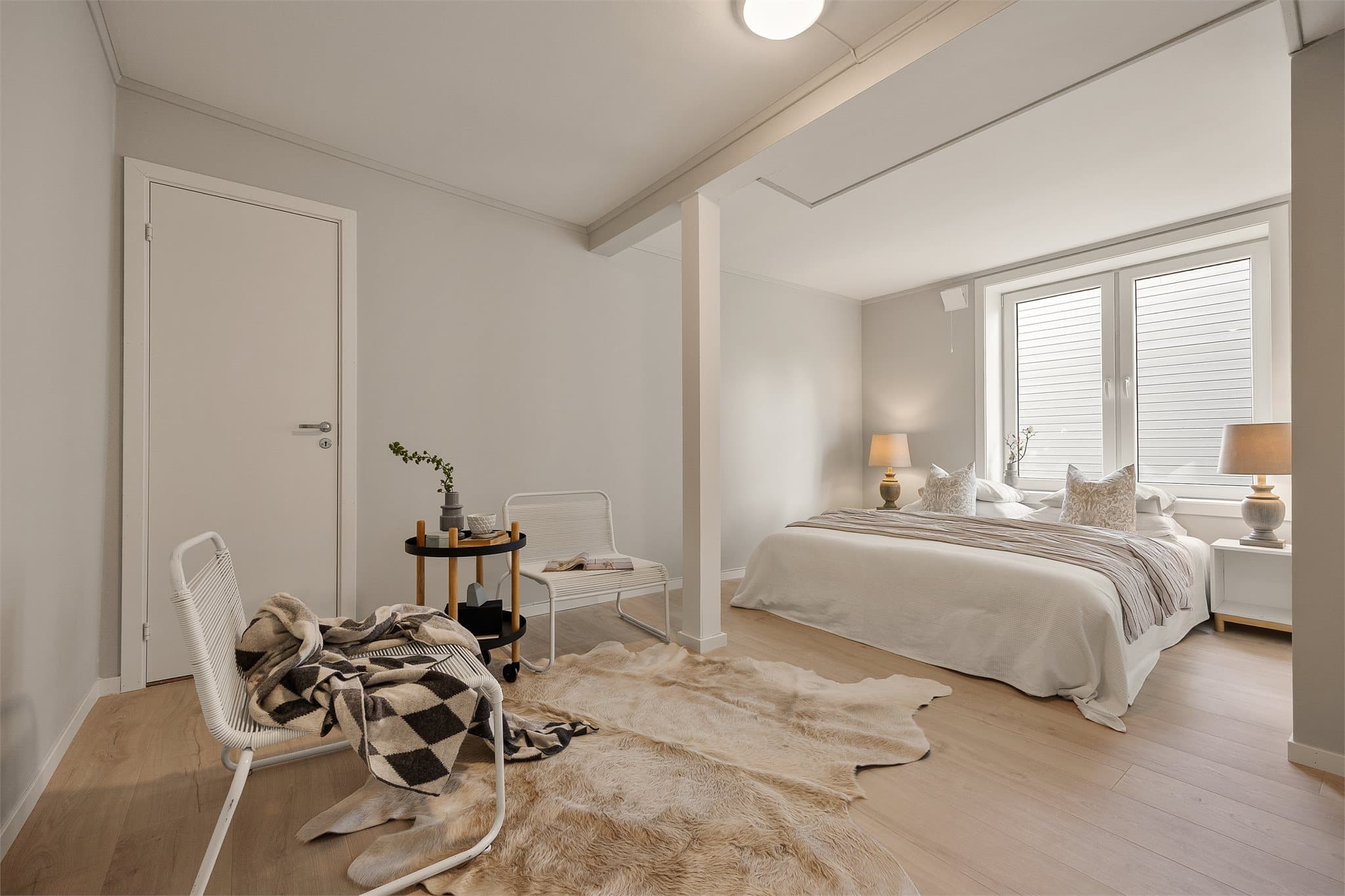 Lyst og romslig hovedsoverom med store vinduer som slipper inn mye naturlig lys