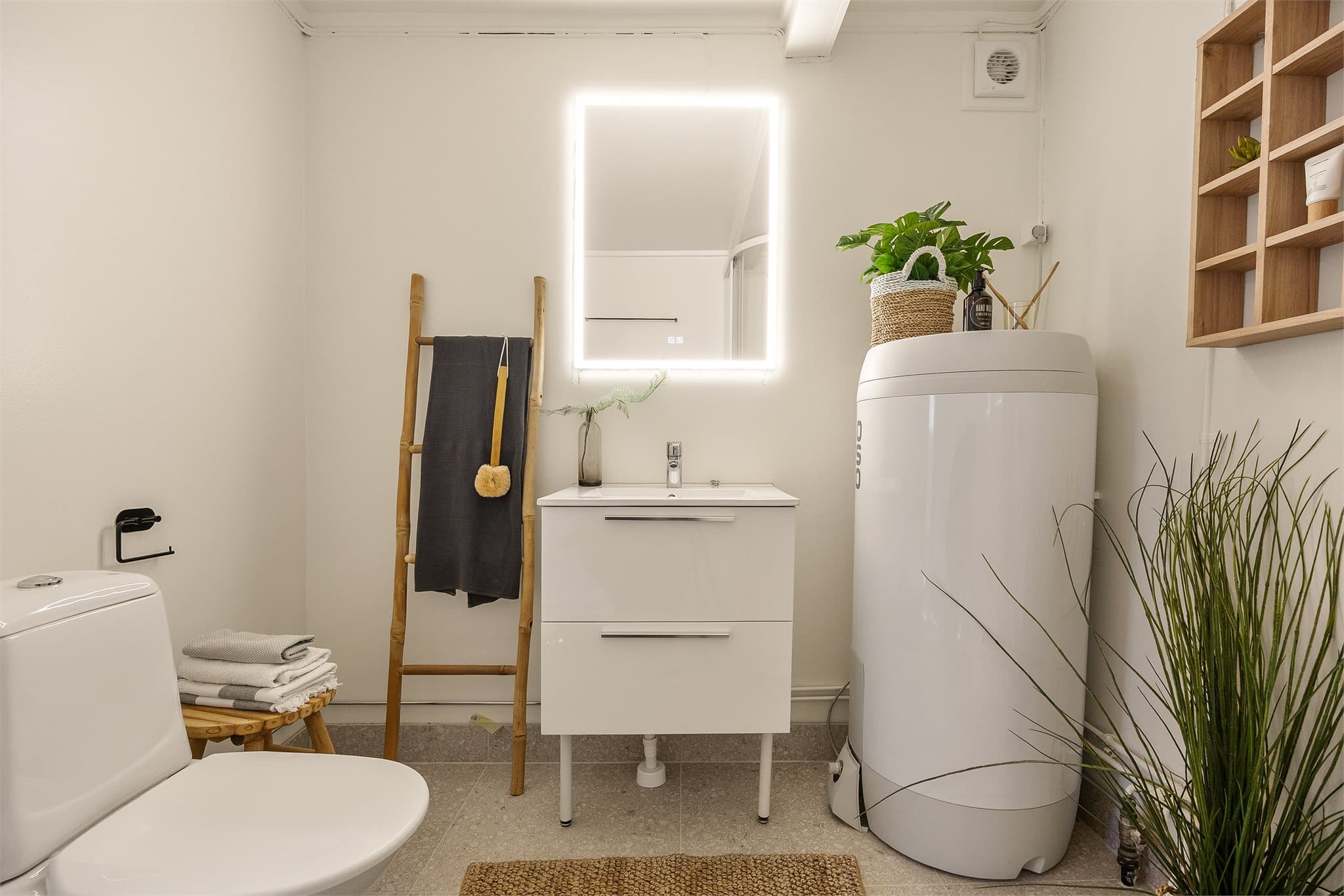 Badet består av dusjkabinett, gulvstående servantinnredning og toalett samt opplegg for vaskemaskin.