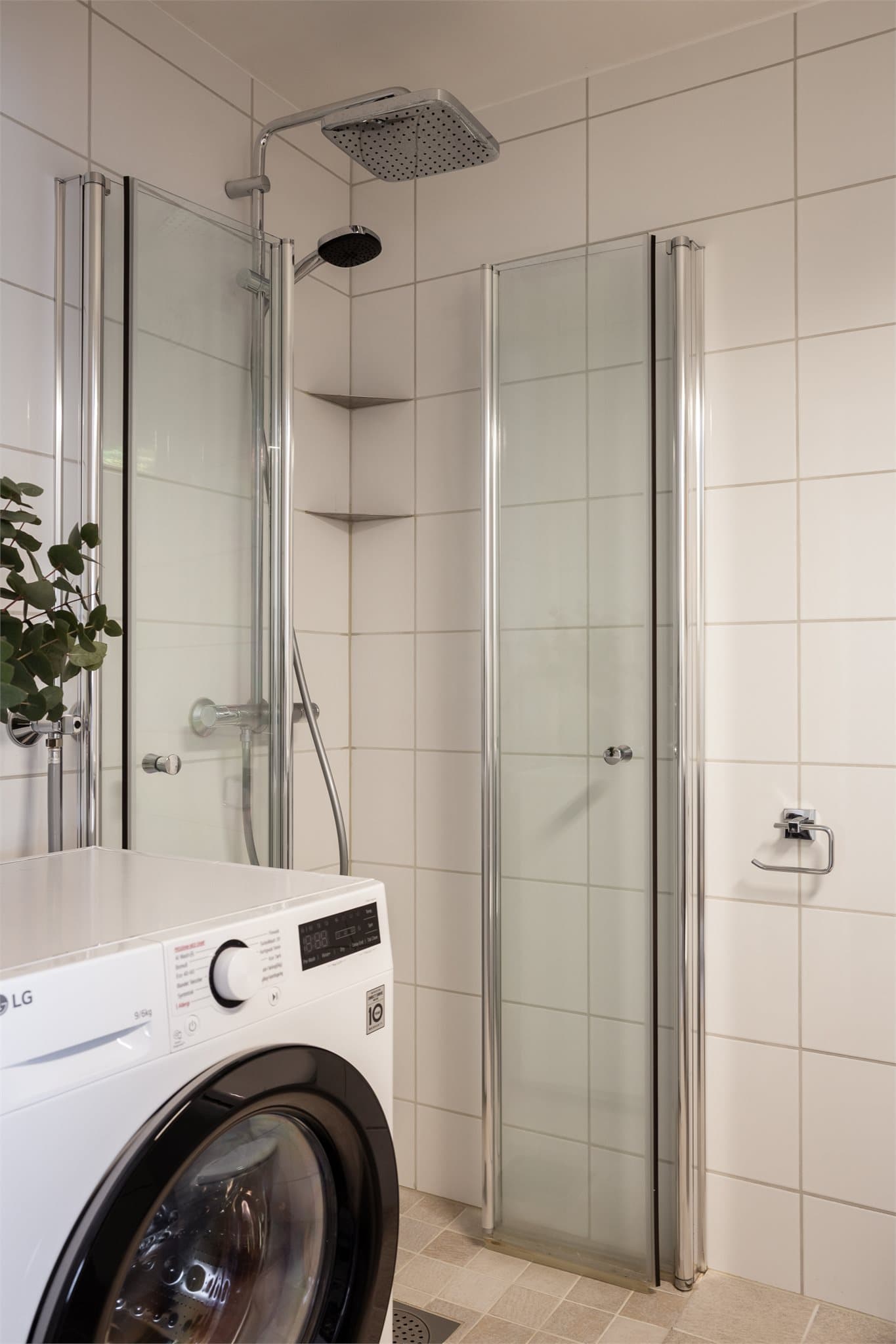 Dusjhjørne med innfellbare dører og opplegg for vaskemaskin.