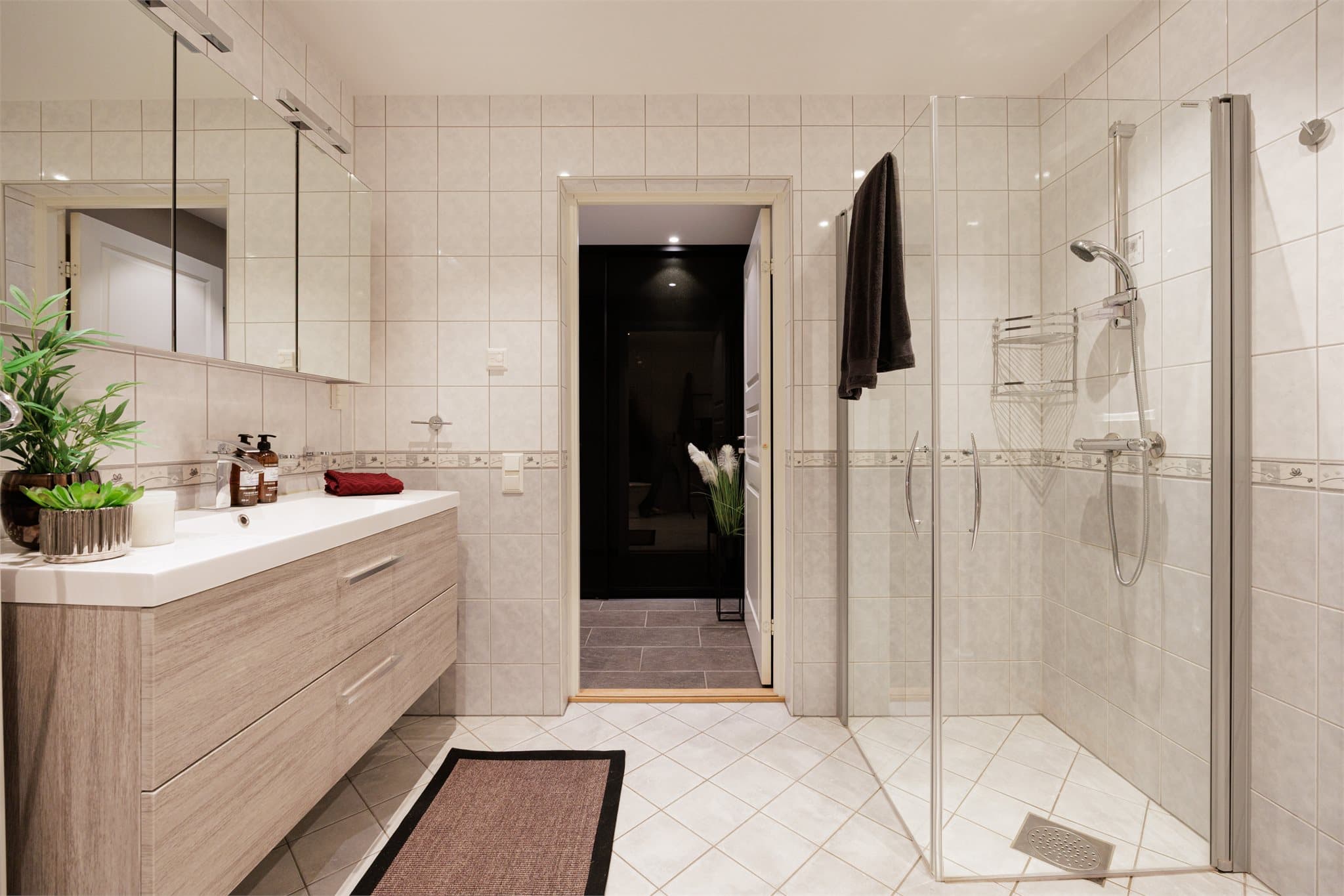 Innredningen på badet består av benkeskap med glatte fronter og veggskap med speil.