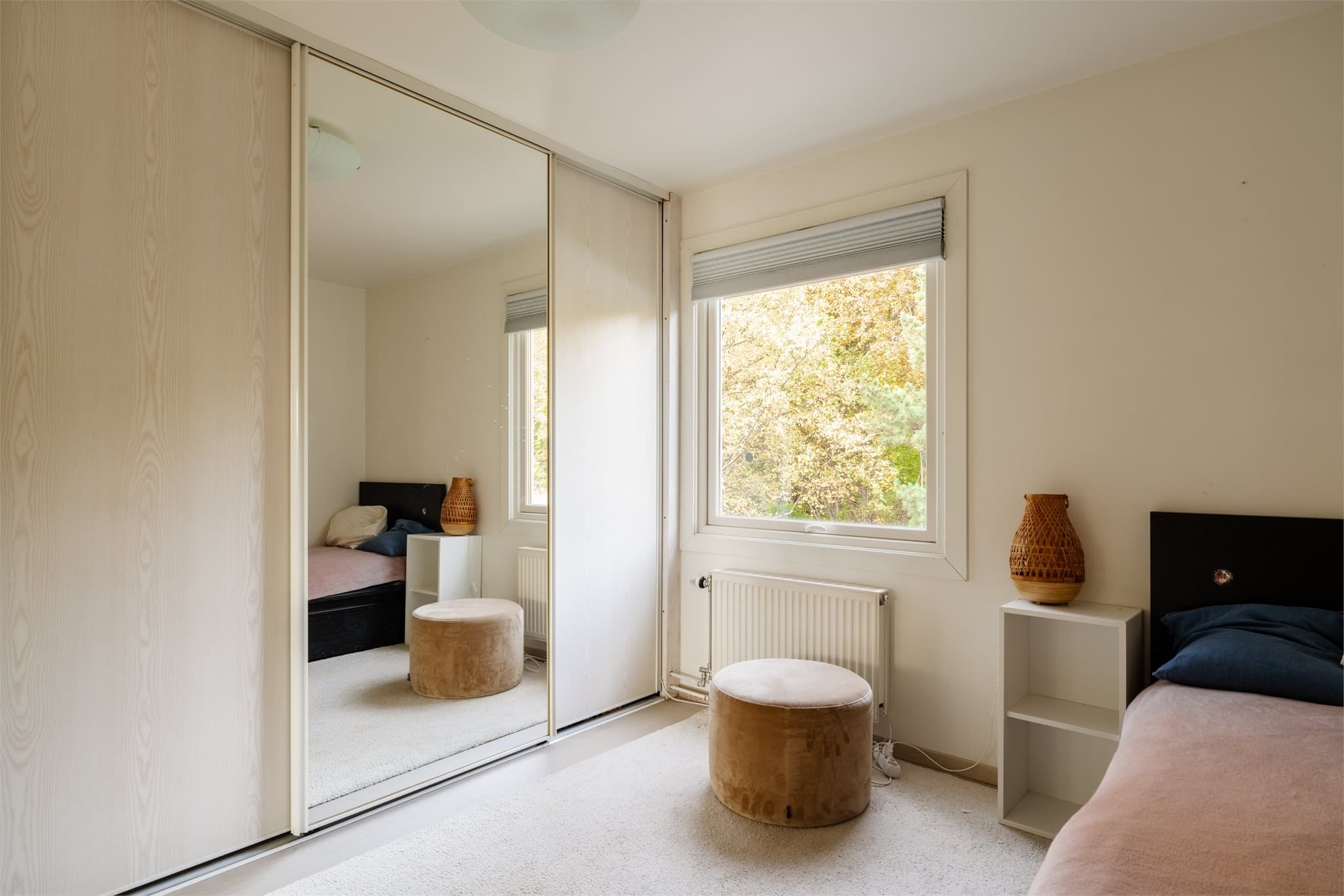 En stor skyvedørsgarderobe gir plass til klær, sko og tilbehør.