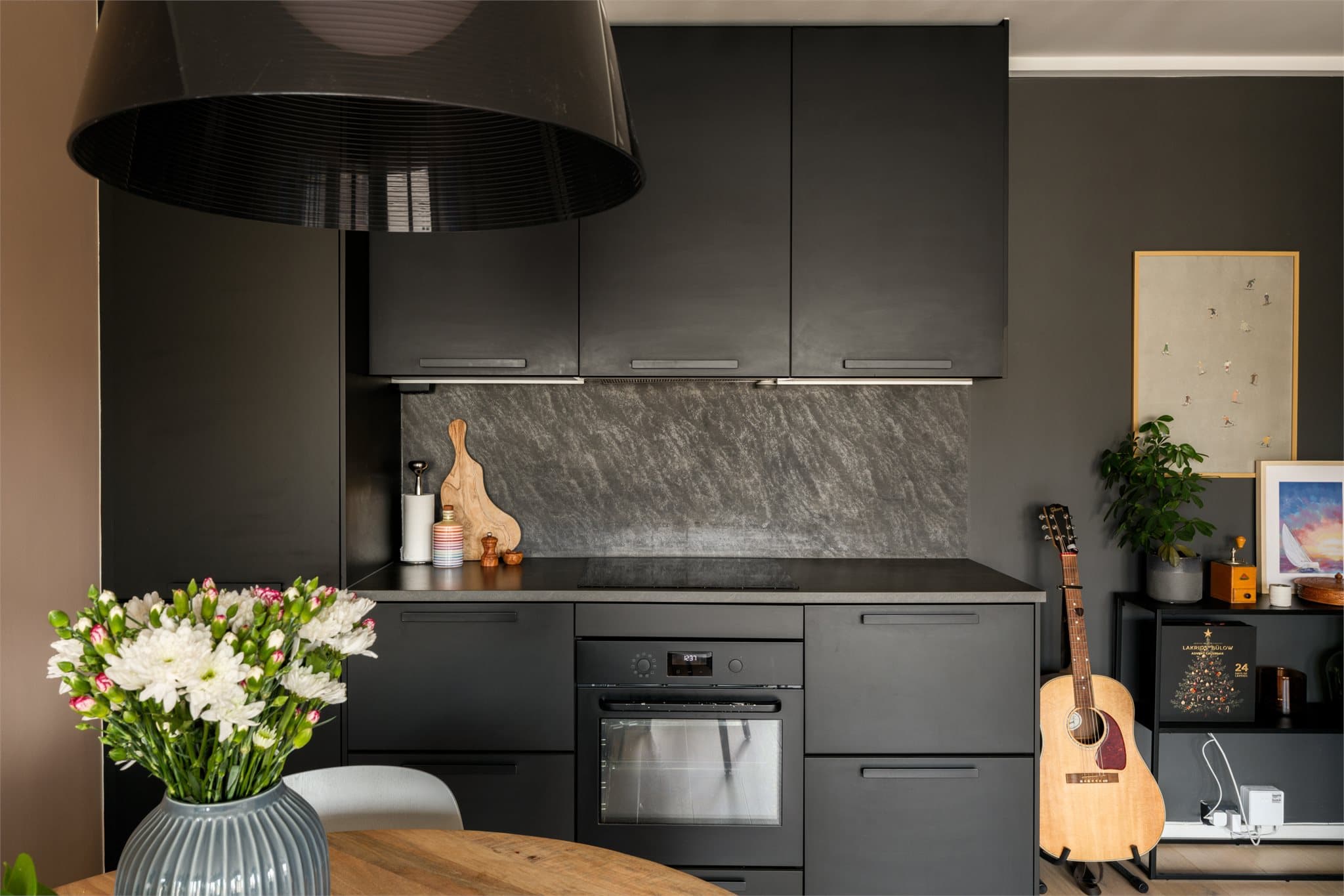 Kjøkkeninnredningen fra Ikea (2018/2019) har et tidsriktig uttrykk med mørke, glatte fronter og laminat benkeplate.