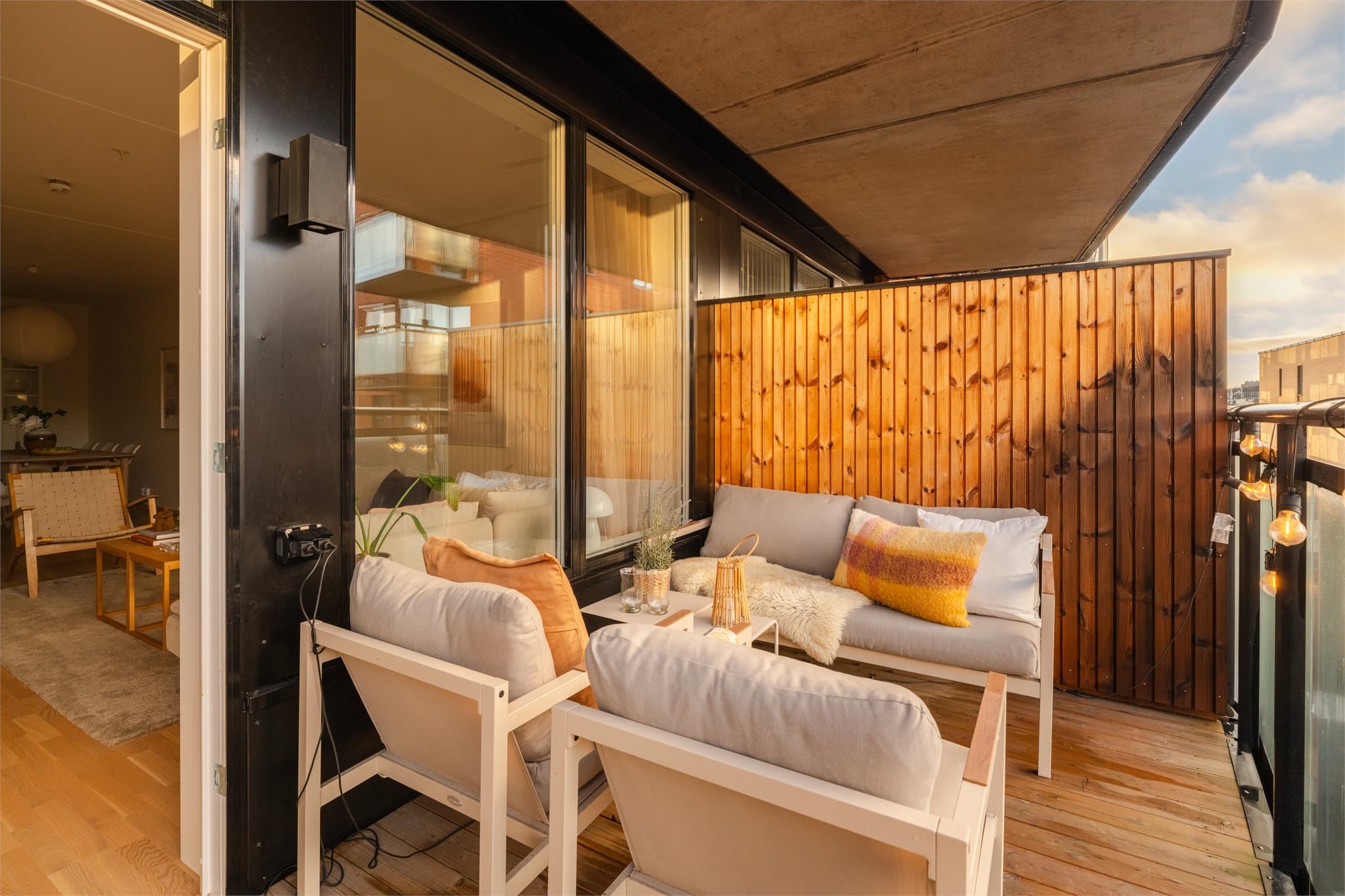 Balkonggulvet er i impregnert trevirke, og rekkverket er i stål med glassplater.