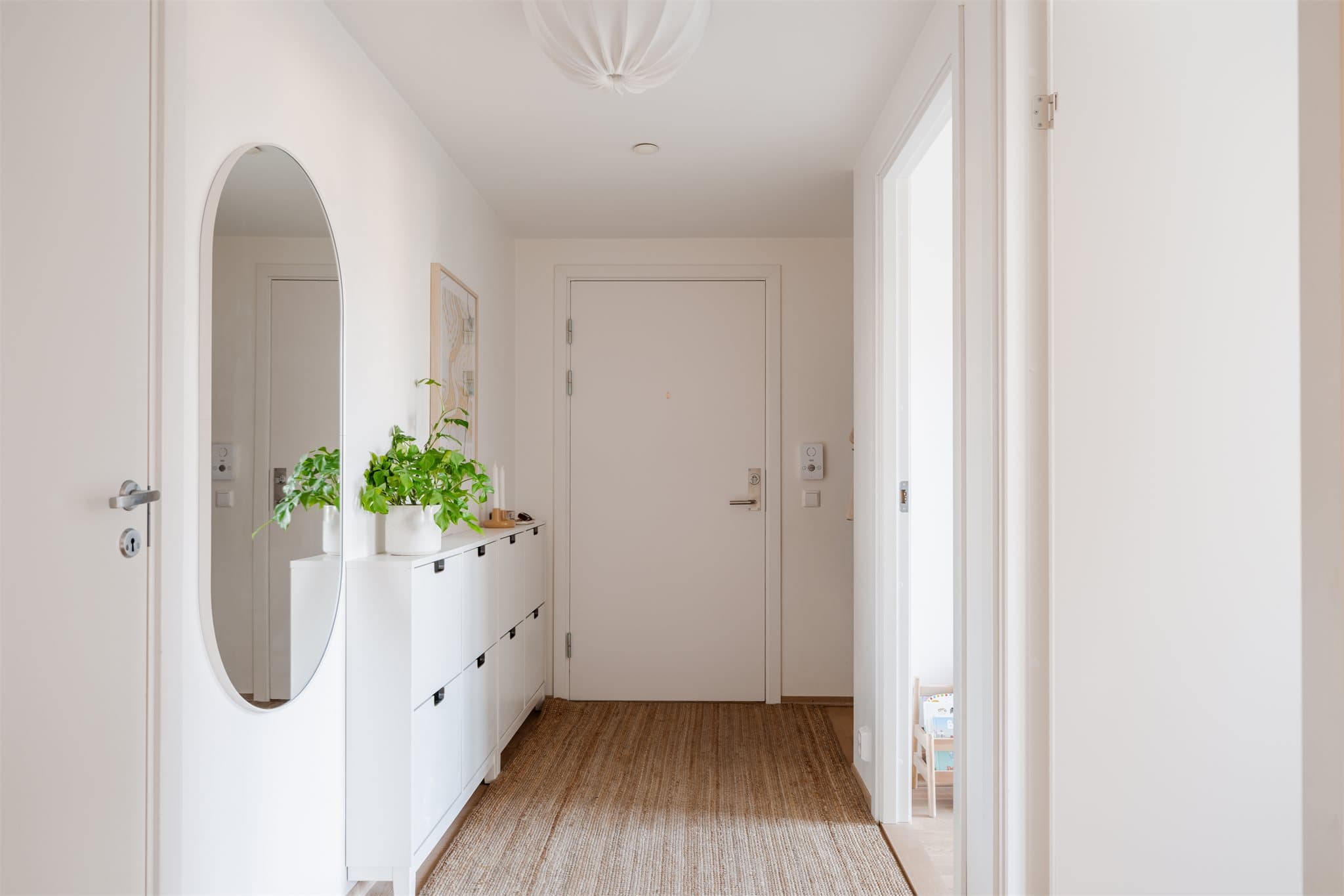 Velkommen inn i en lys entré med 3-stavs parkett på gulvet, som er gjennomgående i leiligheten.