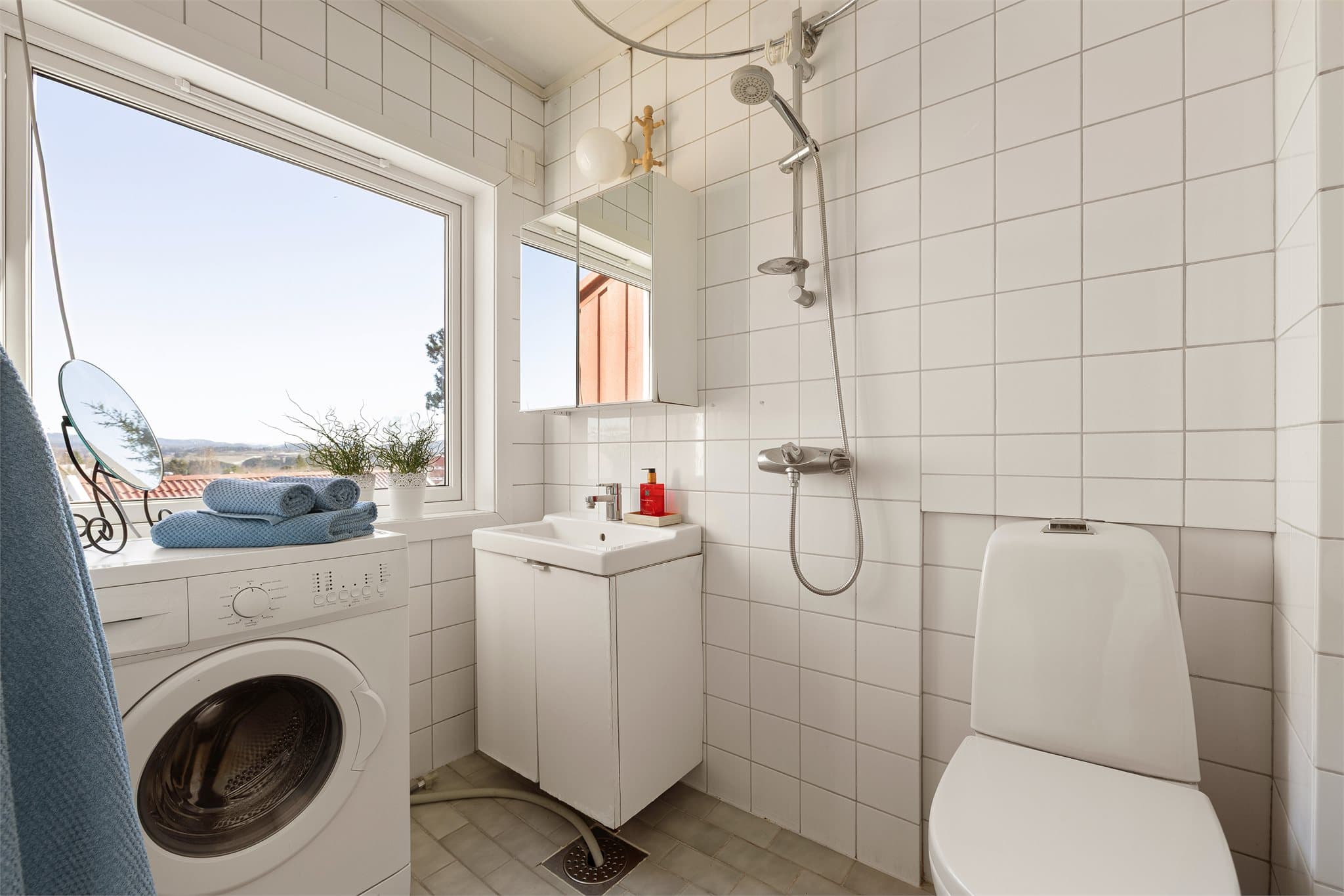 Badet er utstyrt med toalett, dusj og servantinnredning.