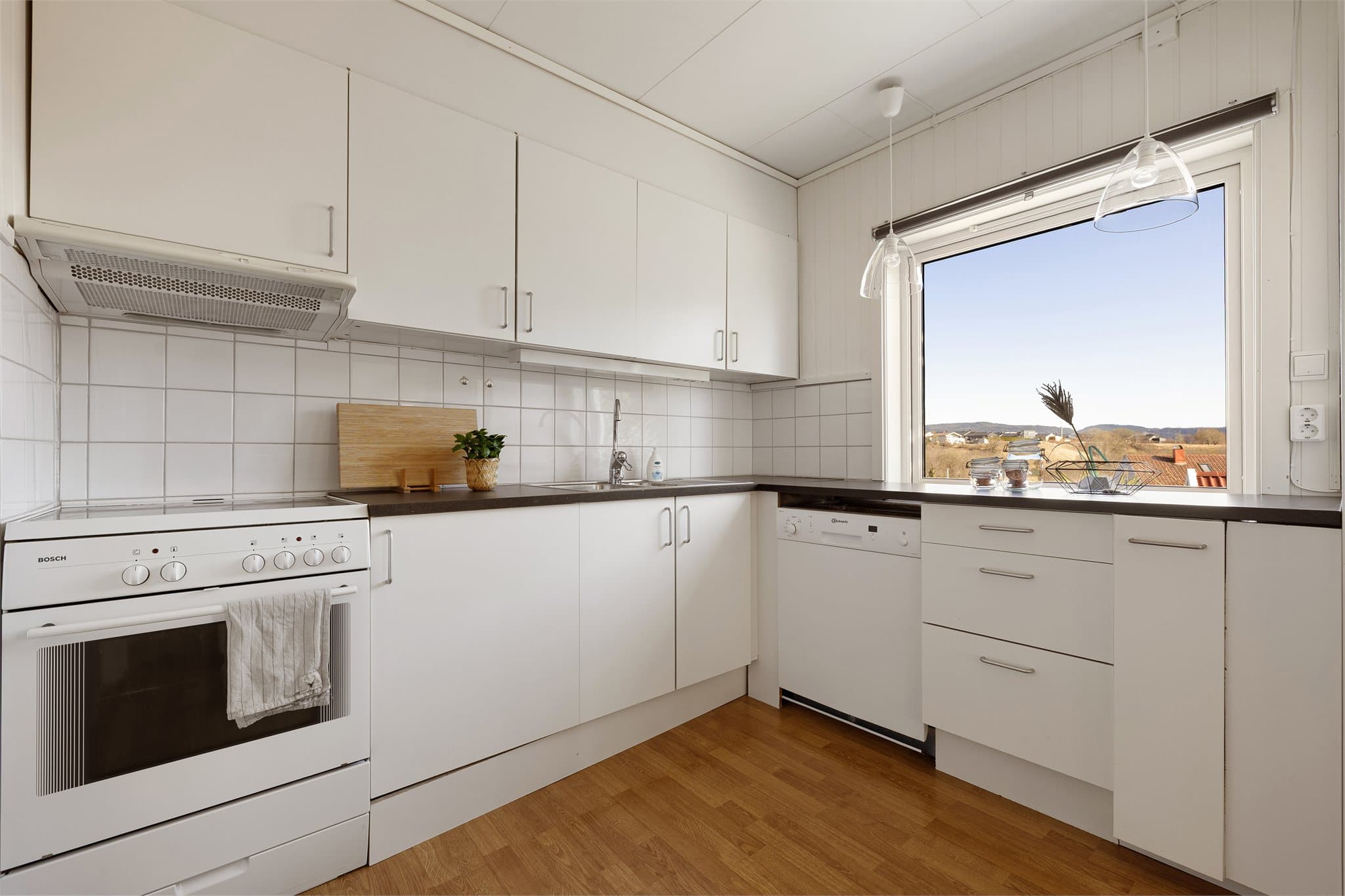 Kjøkkenet ligger separat og fremstår lyst og tidløst med rikelig lagringsplass.