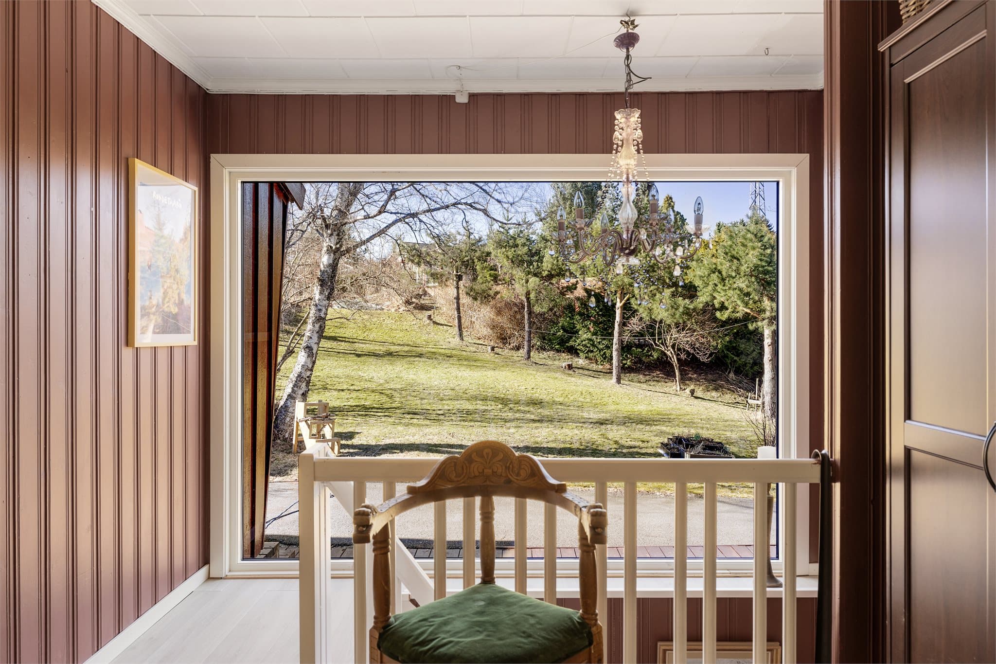 Store vindusflater gir rikelig med dagslys og flott utsikt mot hage og natur.