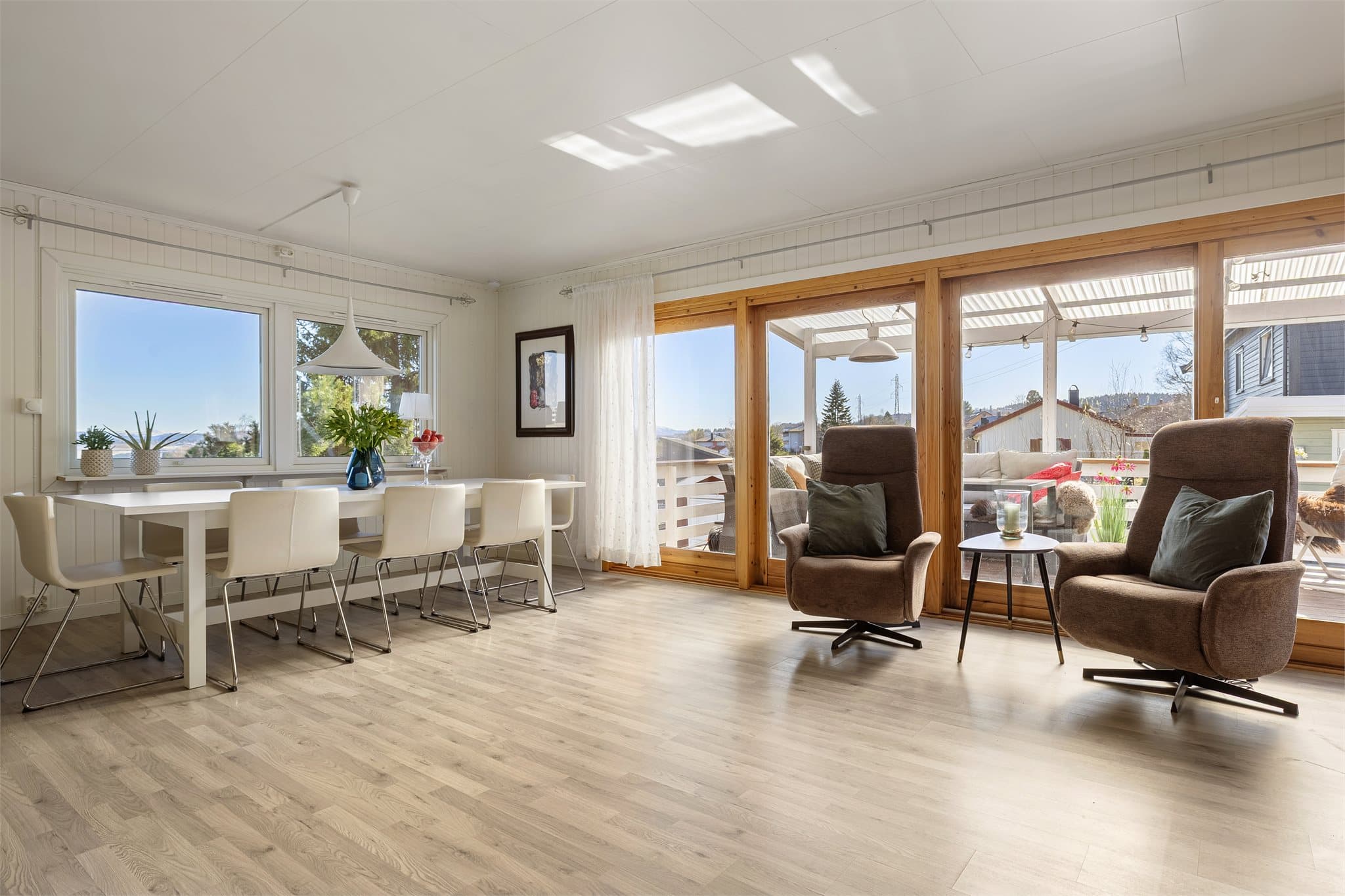 Store vindusflater i flere himmelretninger sørger for rikelig med naturlig lysinnslipp til stuen.